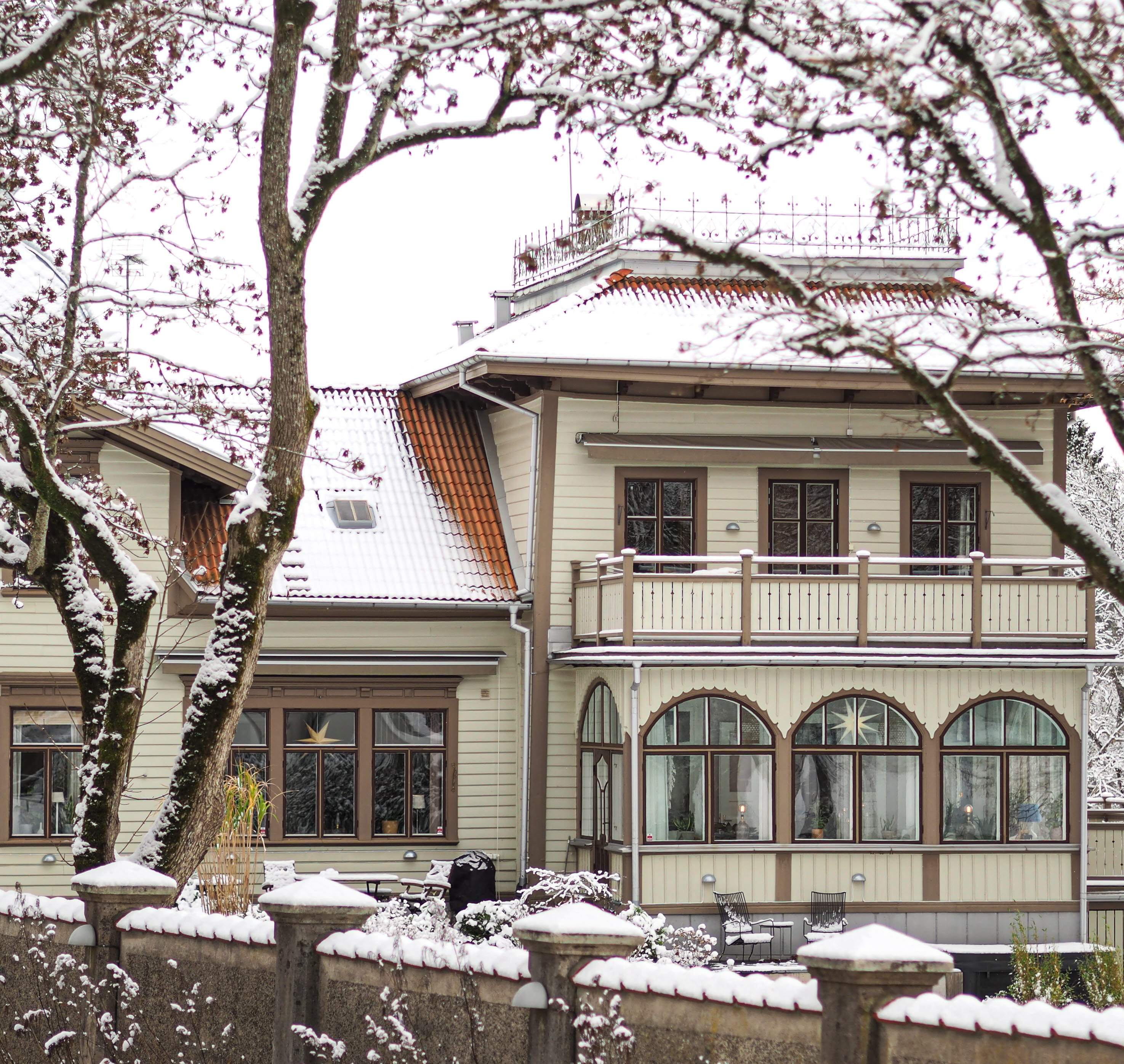 En bild på ett vackert trähus med ett snötäcke på taket