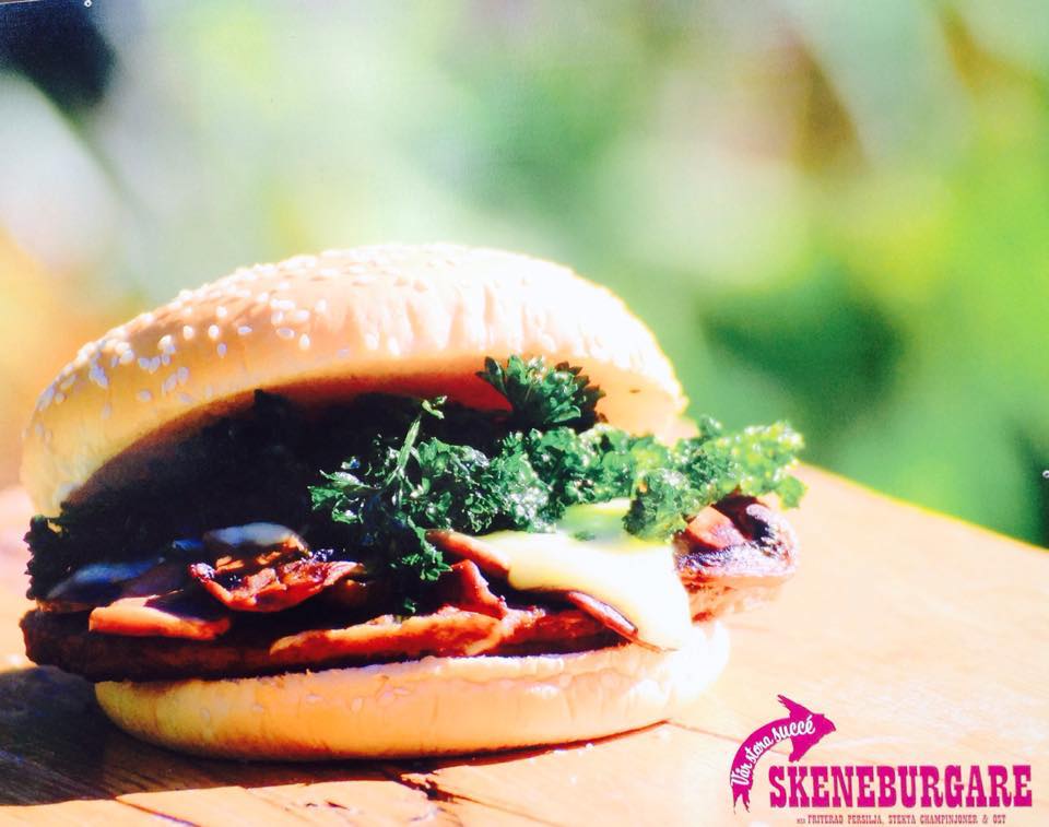 En närbild på en hamburgare på ligger på ett bord utomhus.