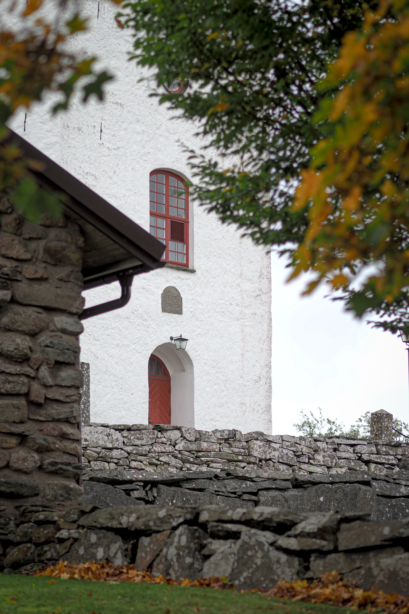 En närbild på ett kyrktorn med rödmålad ingång.