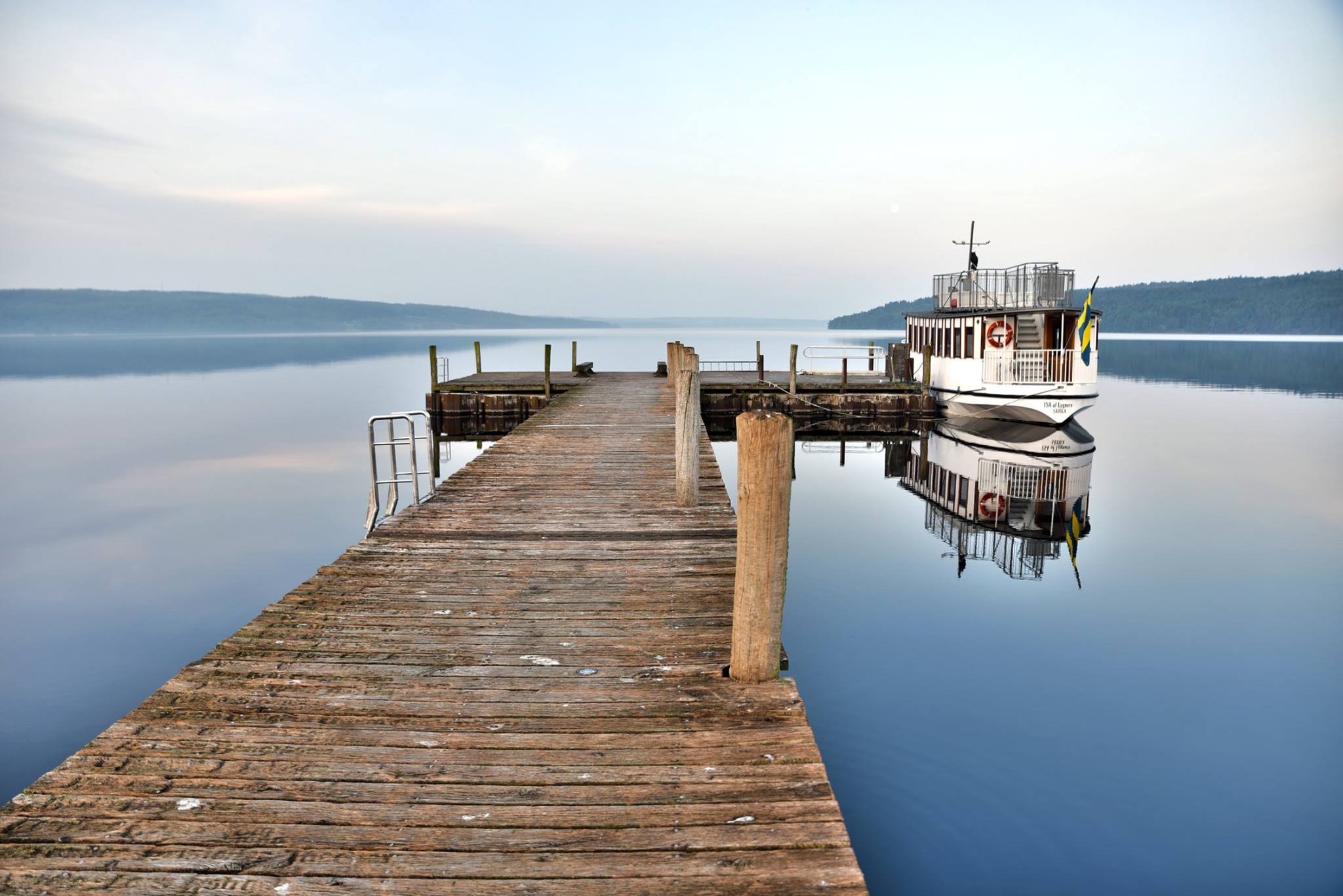 En båt som ligger förtöjd vid en stor brygga av ek.