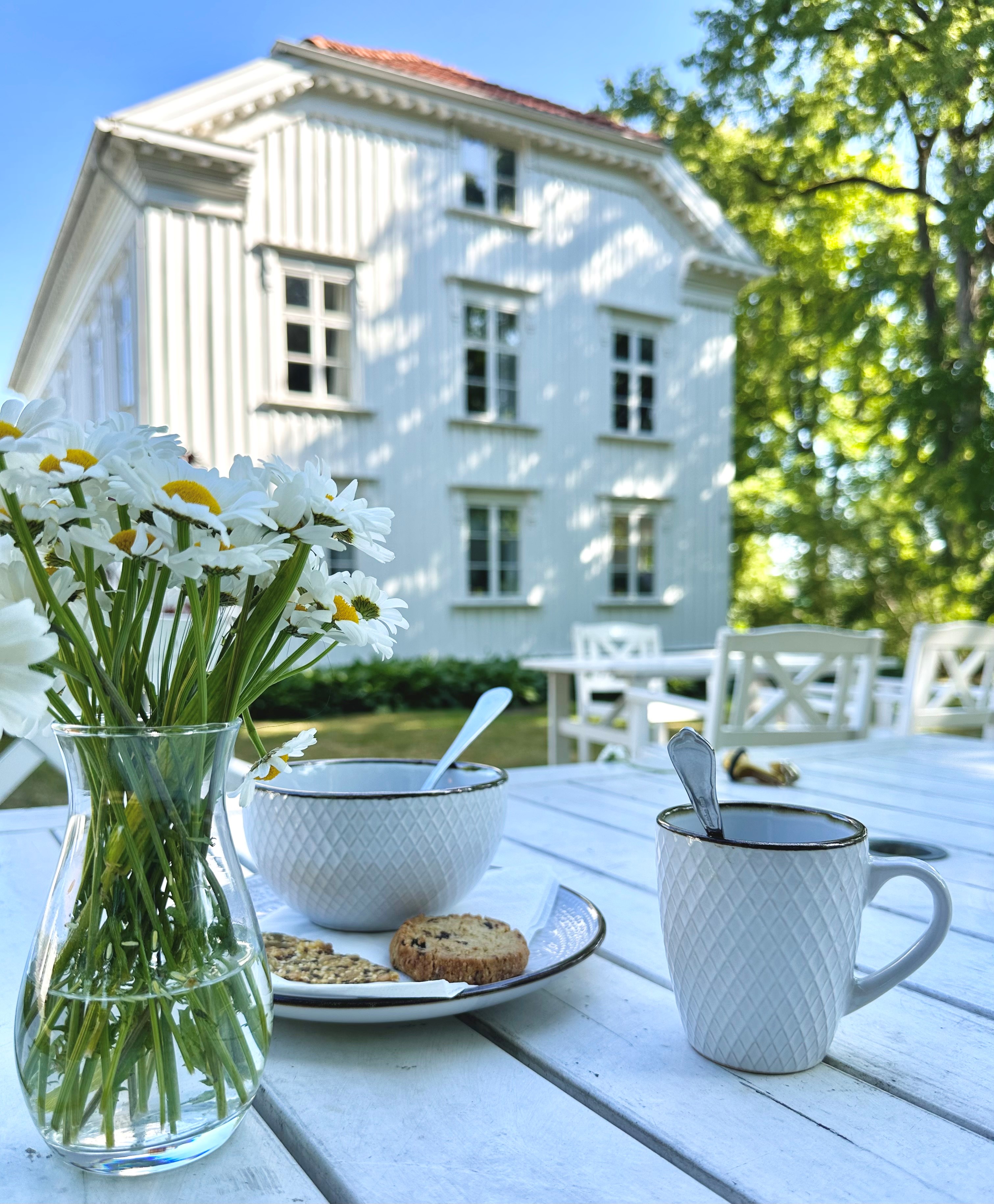 Kinna Bed & Breakfast, dukat fikabord med huset i bakgrunden en sommardag.