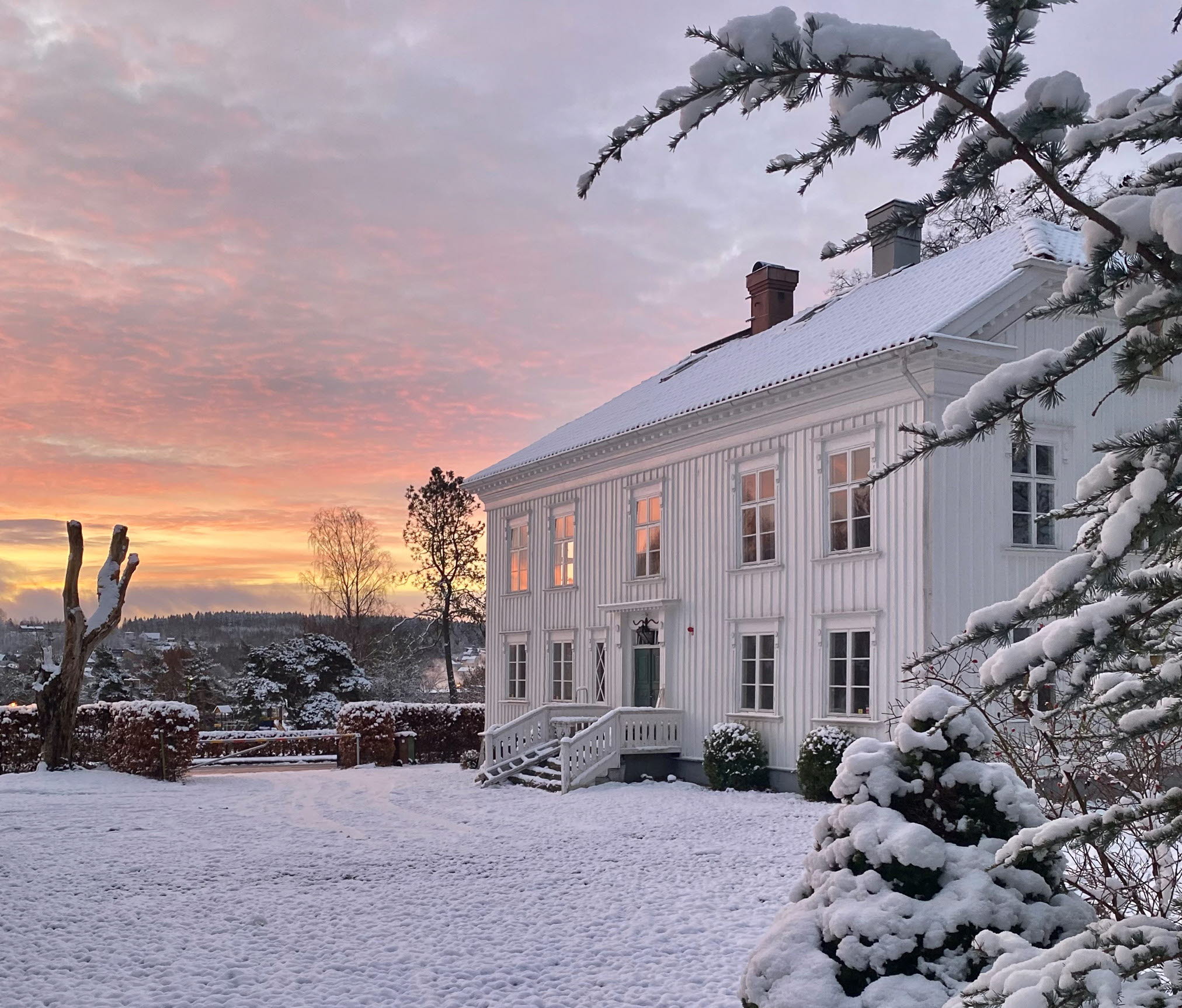 En bild på en förläggargård i vinterlandskap.