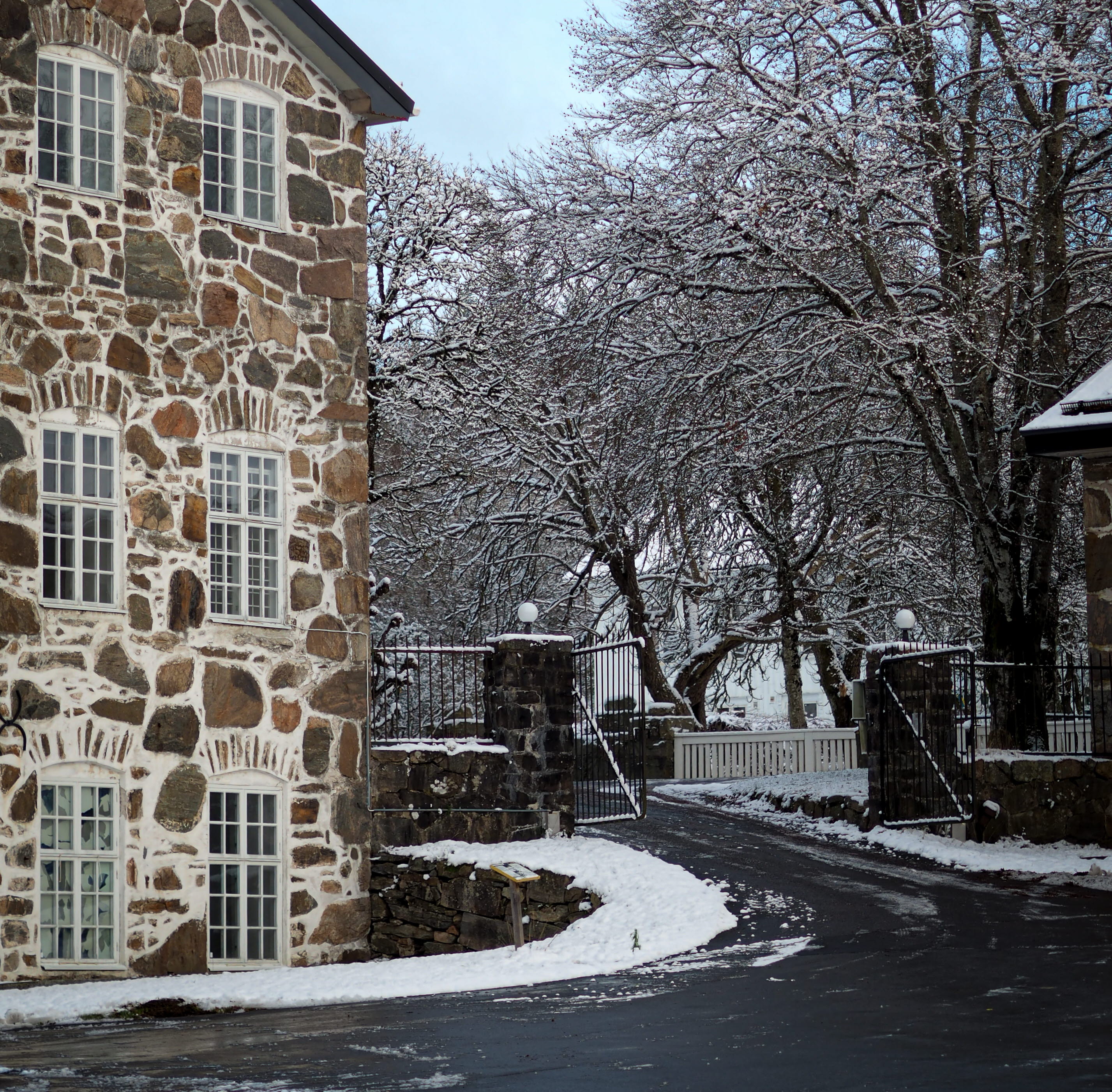 En närbild på en vägg på gammal fabrik med en fasad av natursten och vita, tjocka fogar.