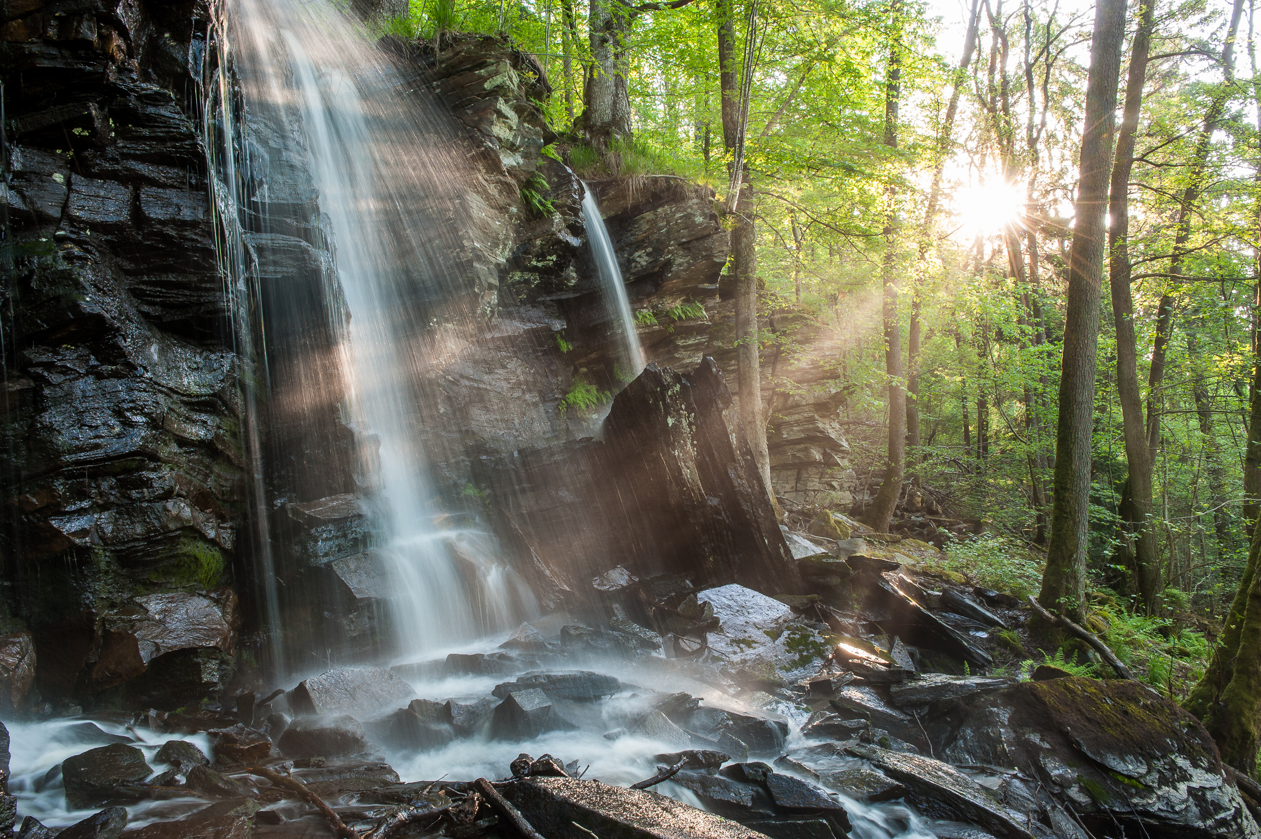 Ramhultafallet, waterfall in Sätila. Sunlight through the trees.