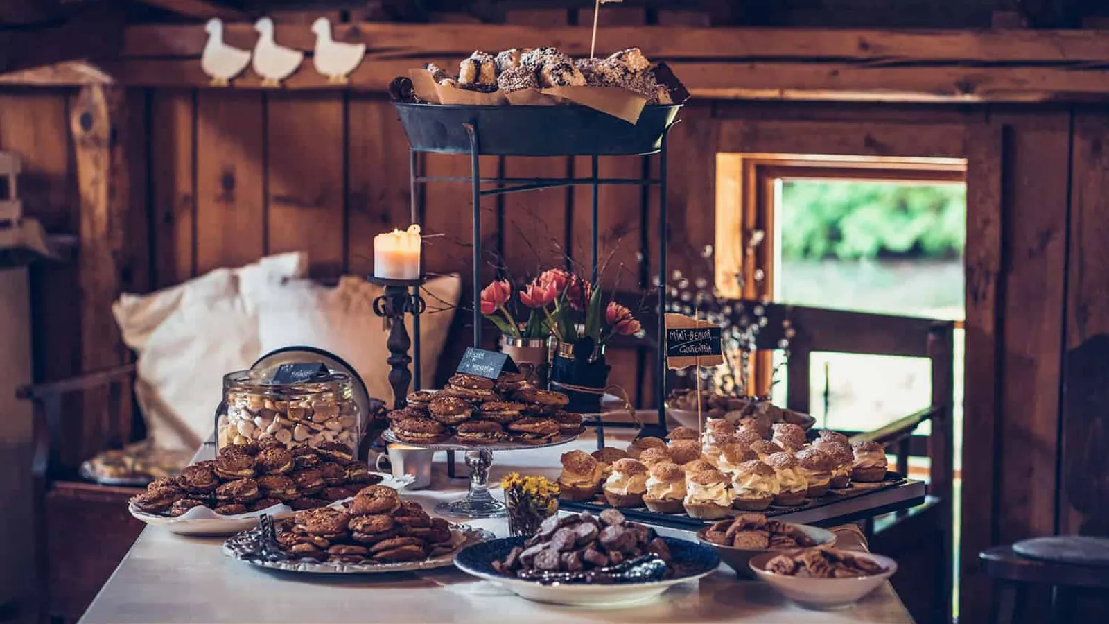 En bild på ett buffébord med massor av fat med kakor och bullar.
