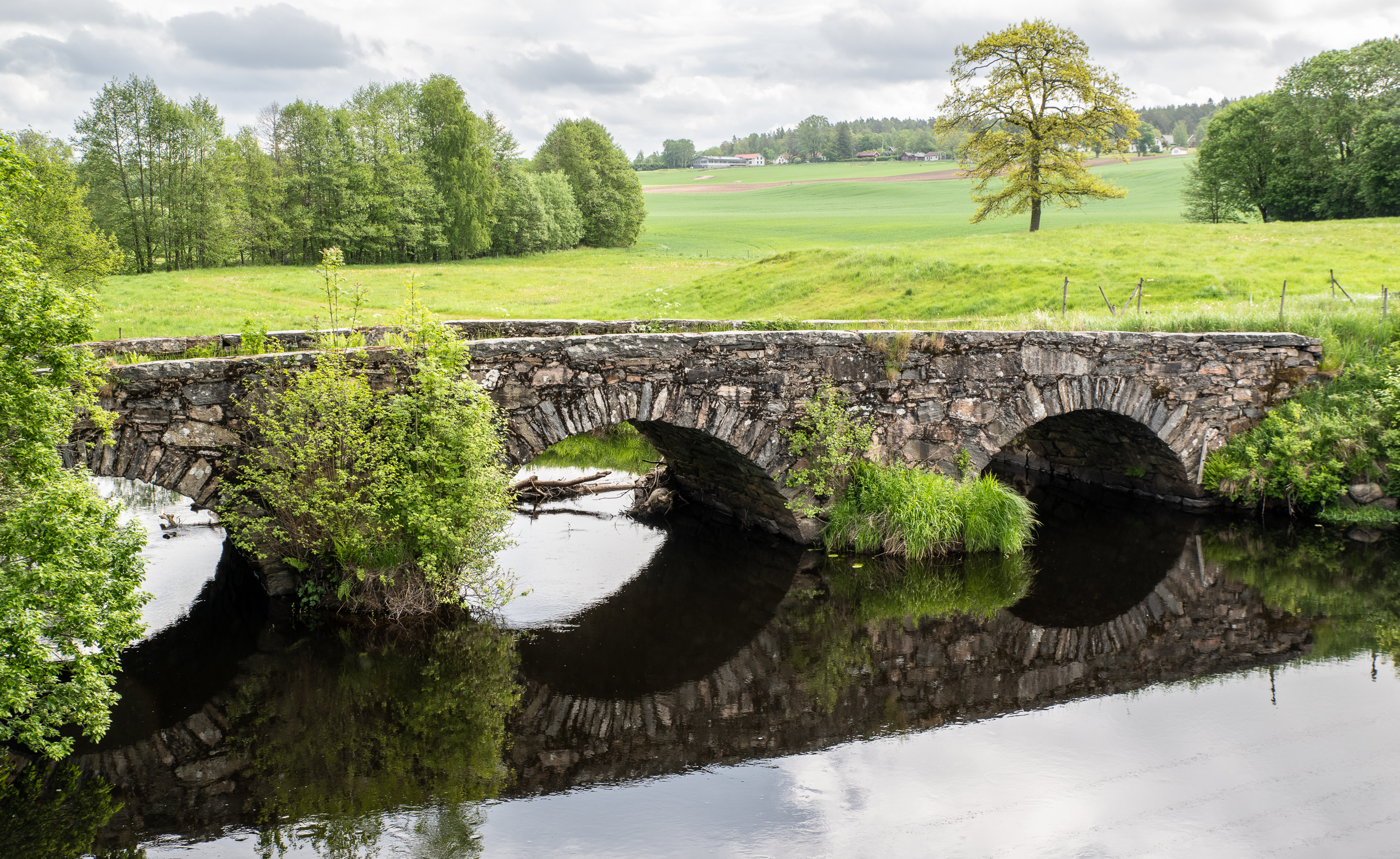 En bild på en stenvalvsbro över en å.