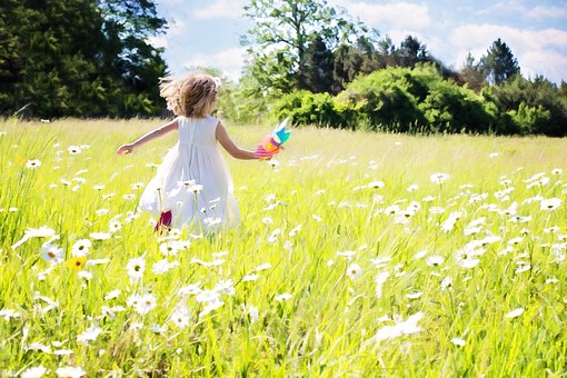 Photo of a girl running in the grass.