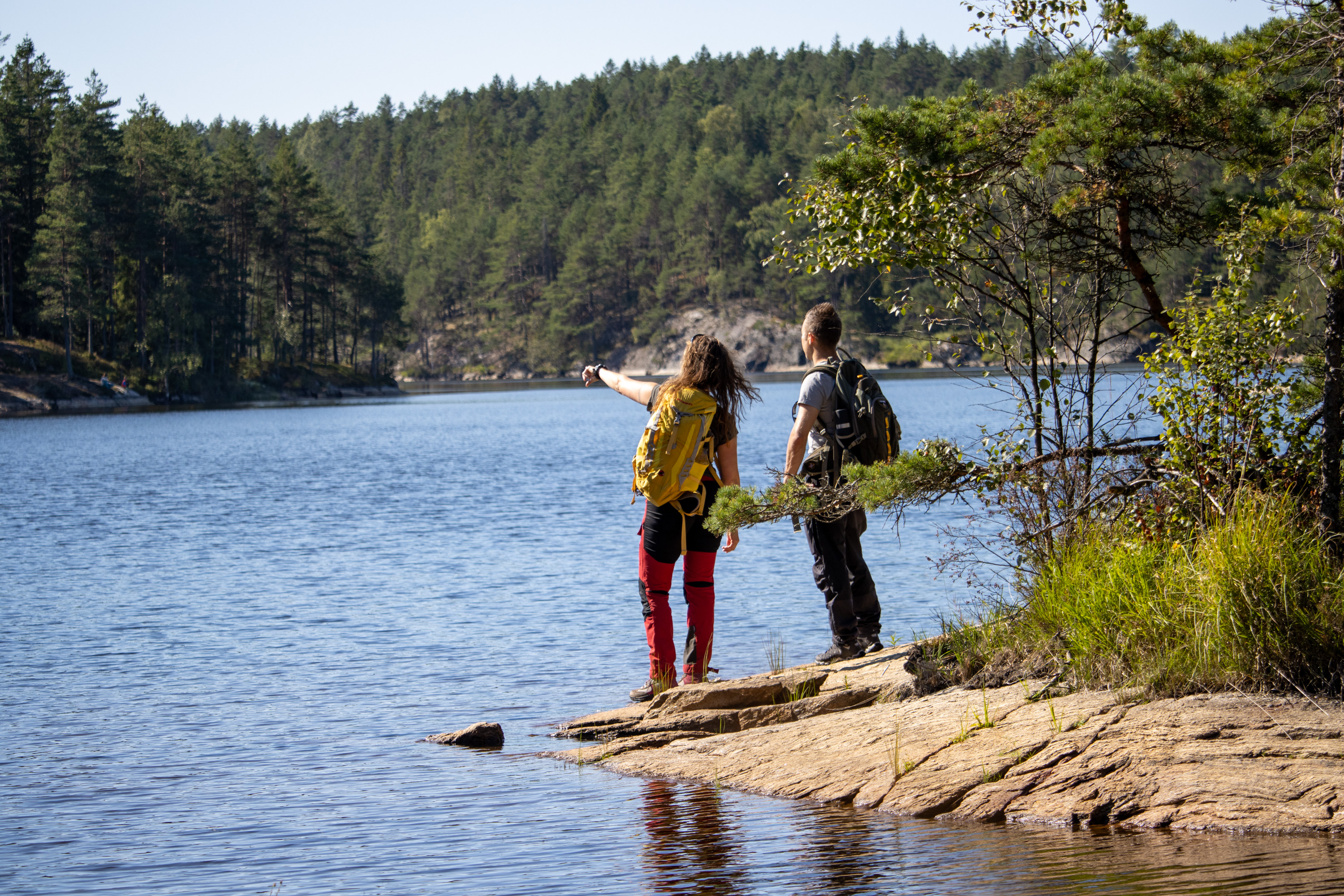 två person med ryggsäckar vid en sjö