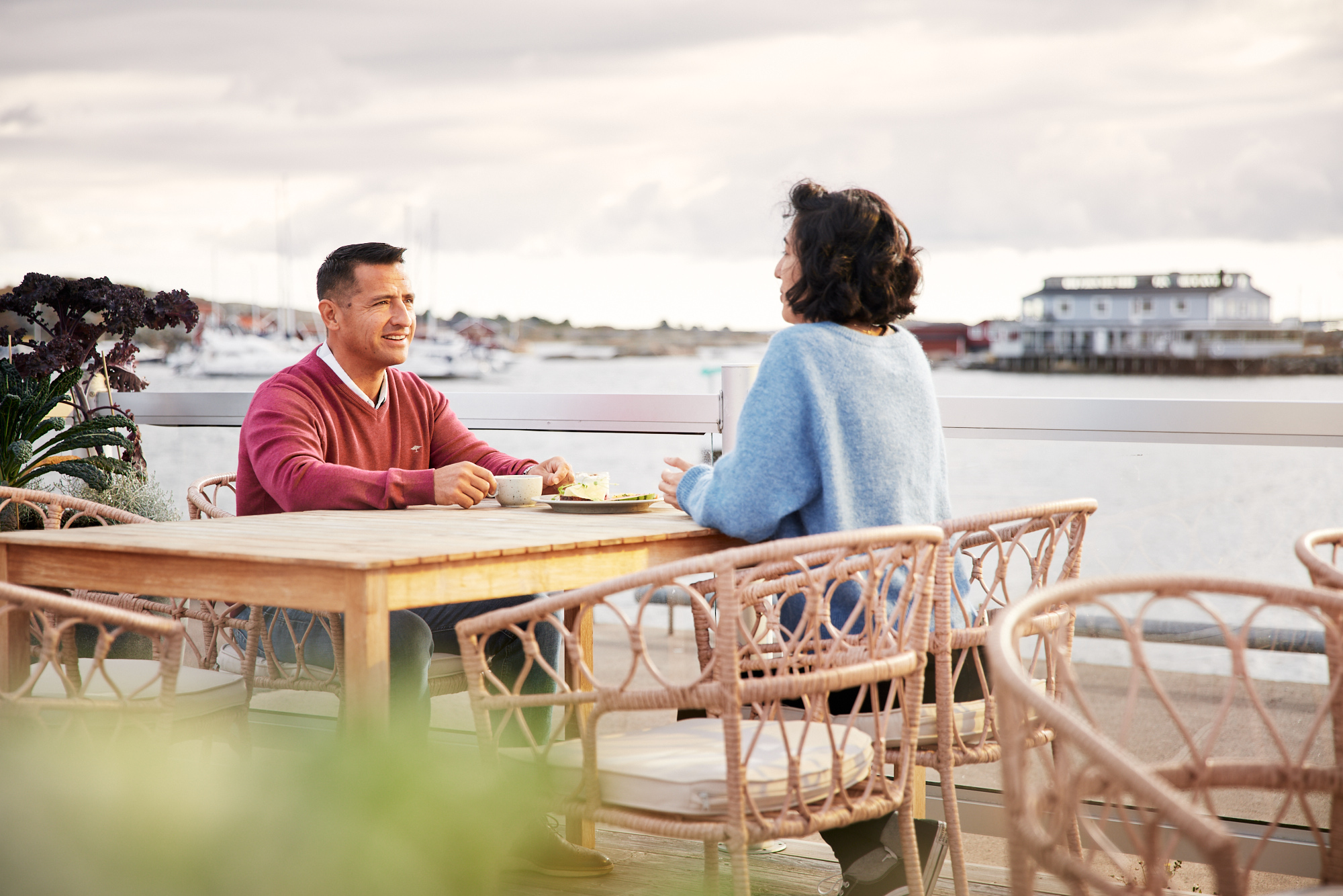 A man and woman enjoy breakfast next to the sea