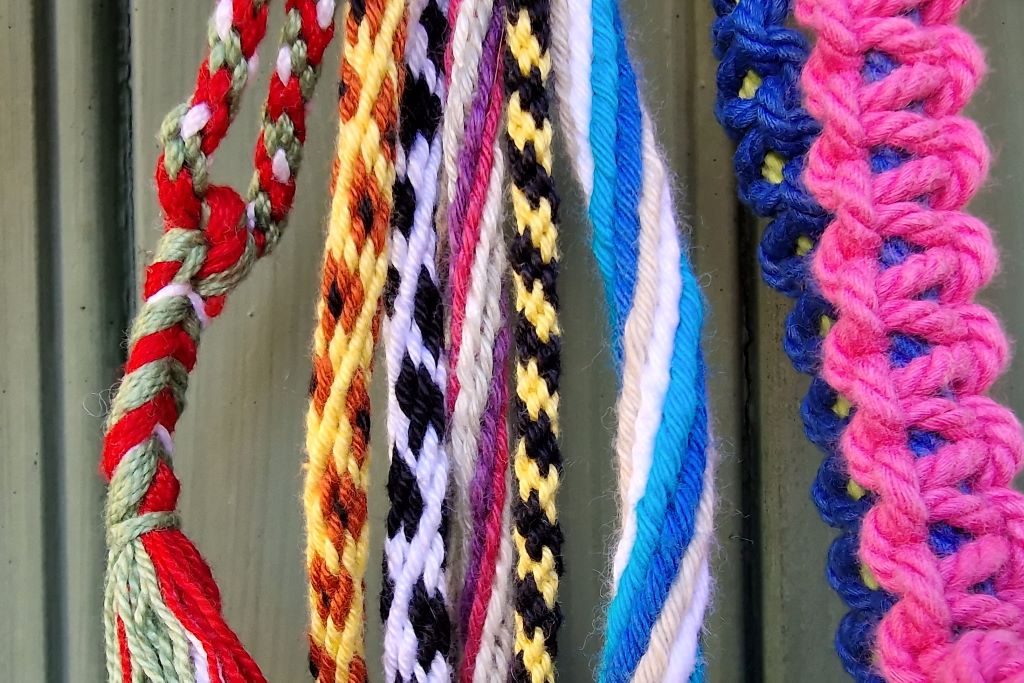 Vi ser virkade flätor i olika färger.