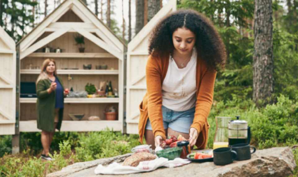 Tjej lagar mat utomhus hos Erikson Cottage
