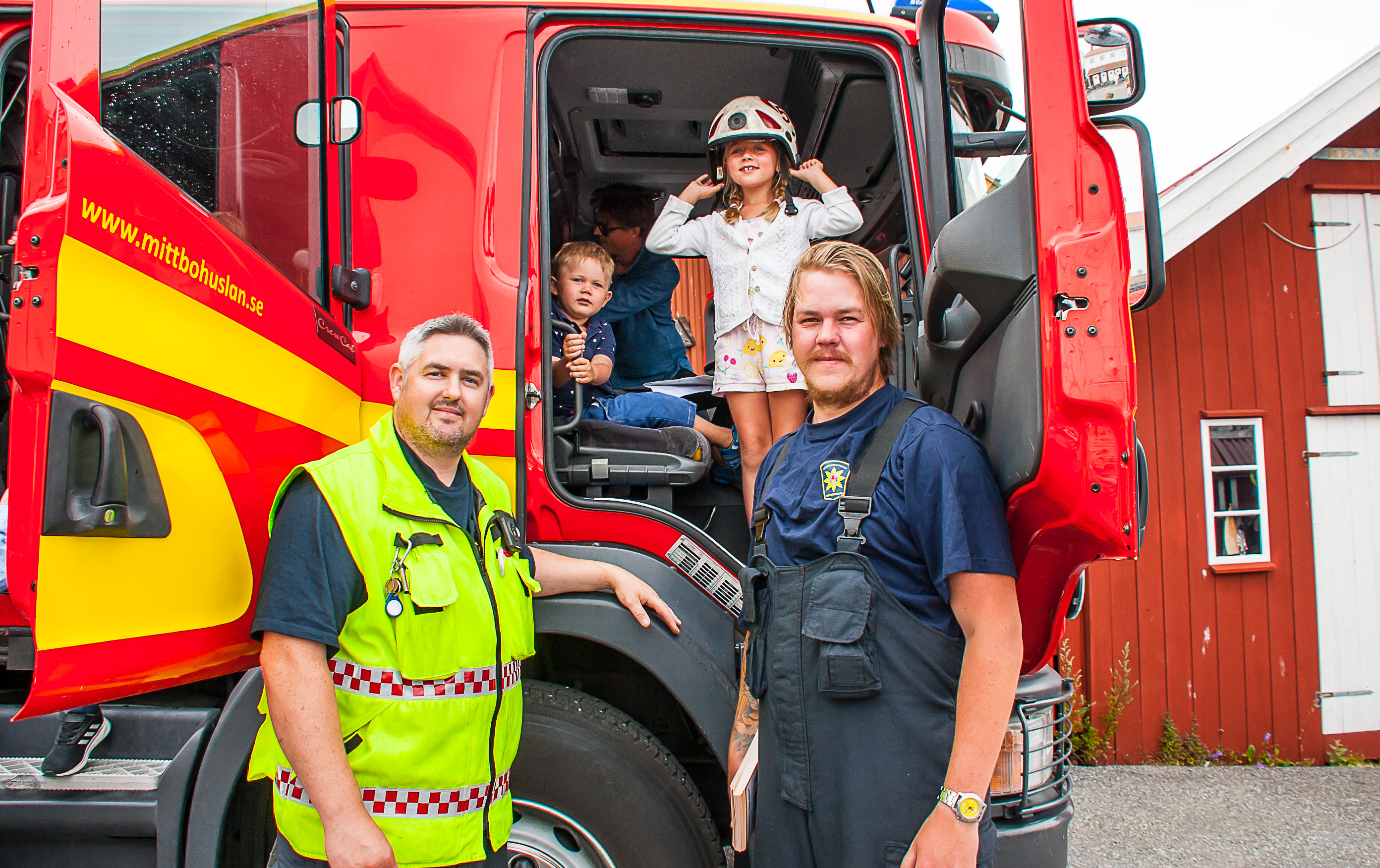 Kanalfesten i Grundsund 2019.  Räddningstjänsten var på plats under lördagen på Östra kajen för att visa upp sig, berätta om sin verksamhet och övervaka Kanalstafetten. Här är det Marcus Ardstål, Styrkeledare på Räddningstjänsten Mitt Bohuslän och Jim Pettersson som visar Felix och Kajsa Ekré insidan av brandbilen.