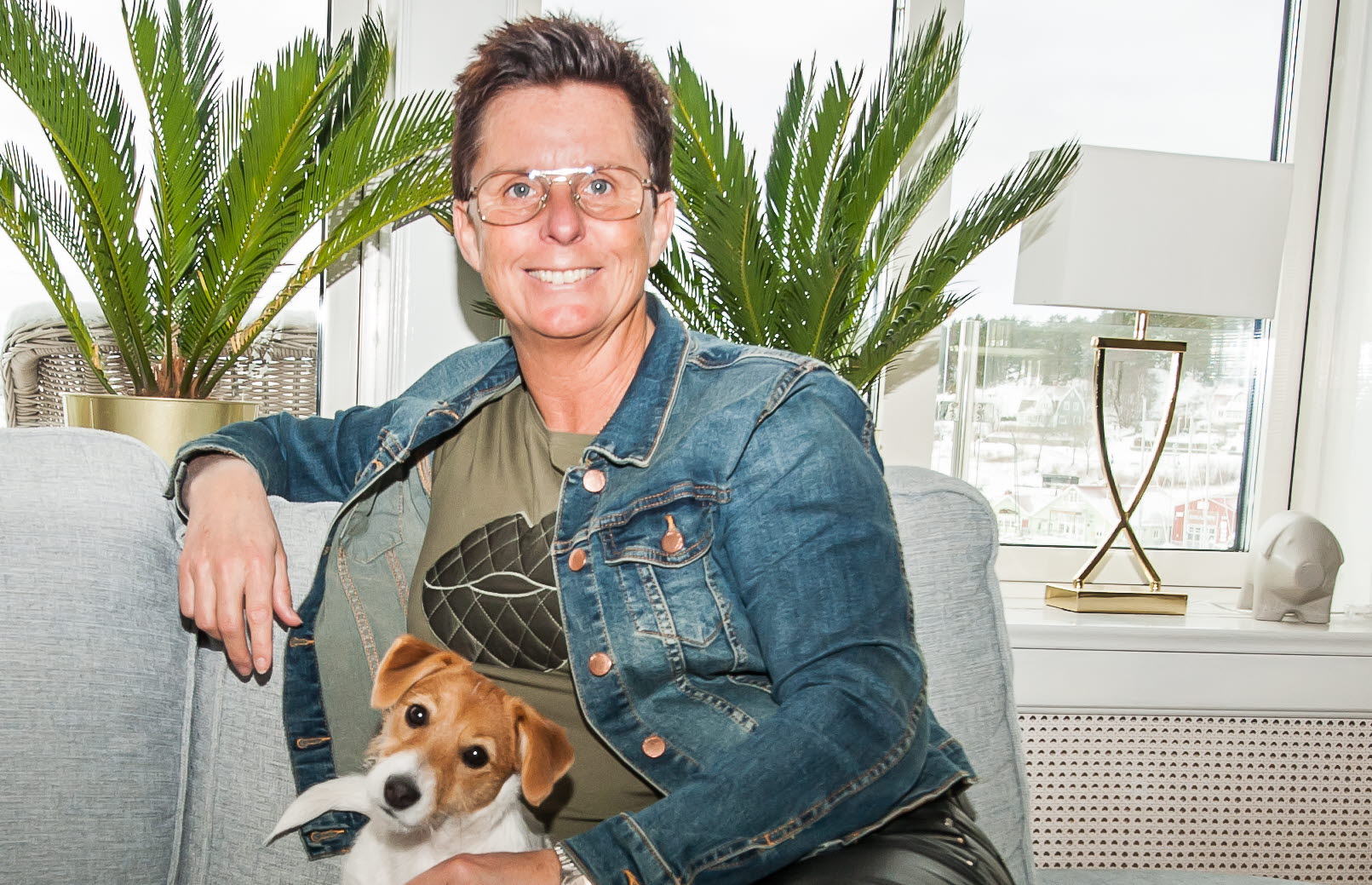 Pernilla Block sitter i sin soffa med hunden Tova. Deltagare Robinson 2023