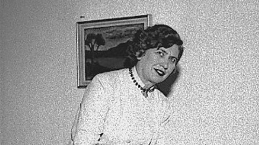 Ett svartvitt foto av Agda Österberg som bär en vit blus och ett mörkt pärlhalsband.