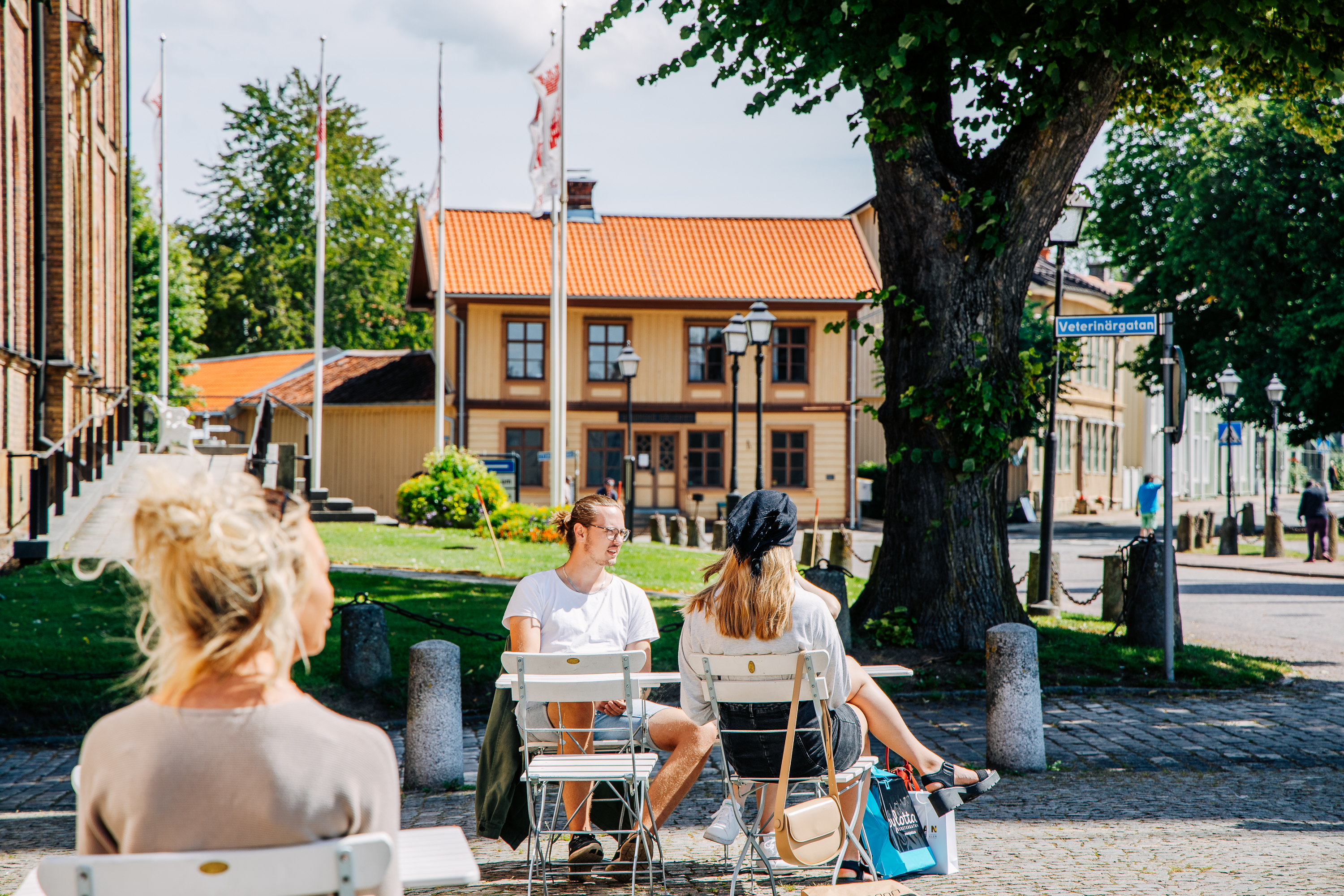 Tre personer sitter på en uteservering i Skara