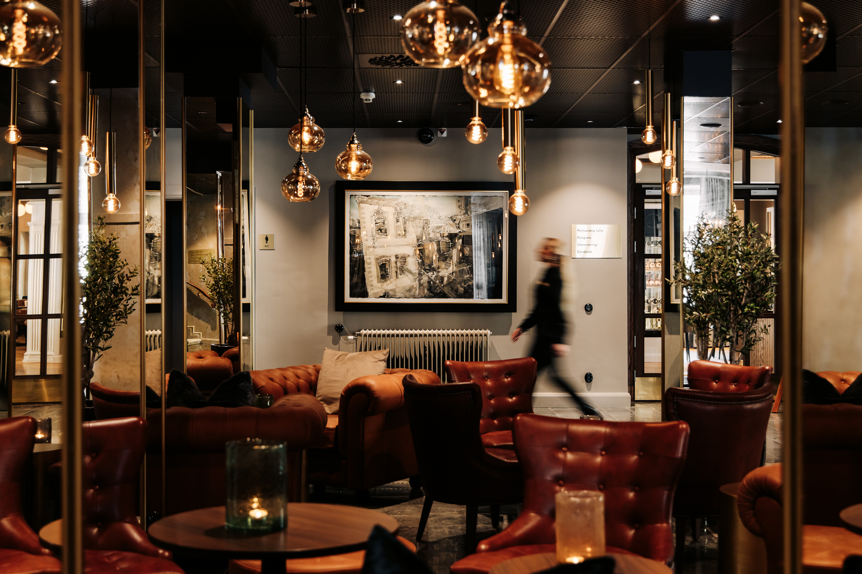 Kvinna passerar en tavla av Lars Lerin på Skara Stadshotell