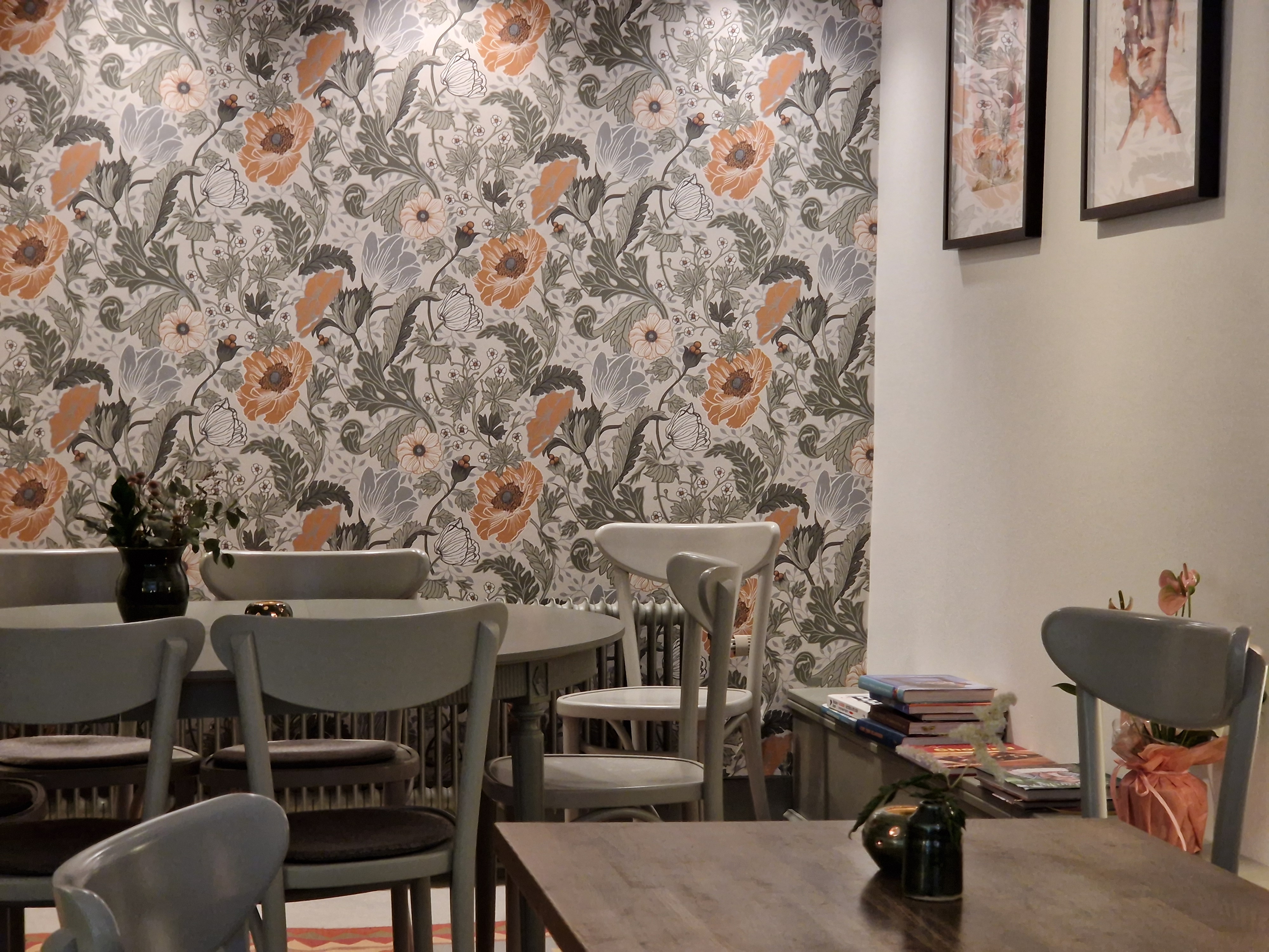 En bild från ett café med blommiga tapeter i gråskala.