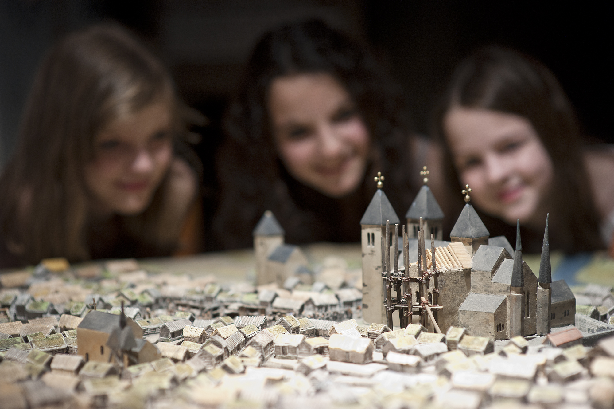 Barn tittar på modell från medeltiden på Västergötlands museum