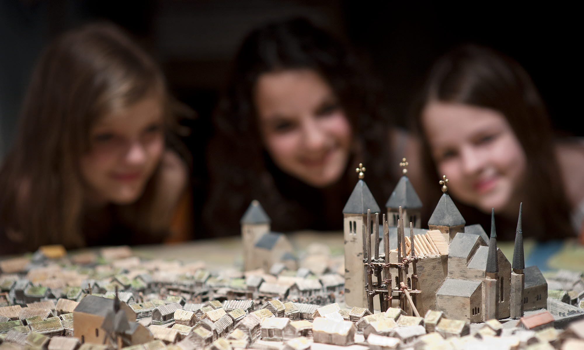 Barn tittar på modell från medeltiden på Västergötlands museum