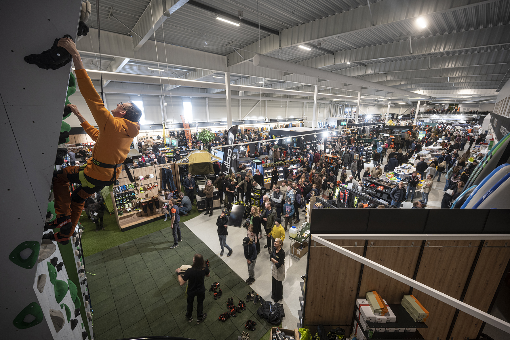 A man climbing a climbing wall inside Astro Sweden.