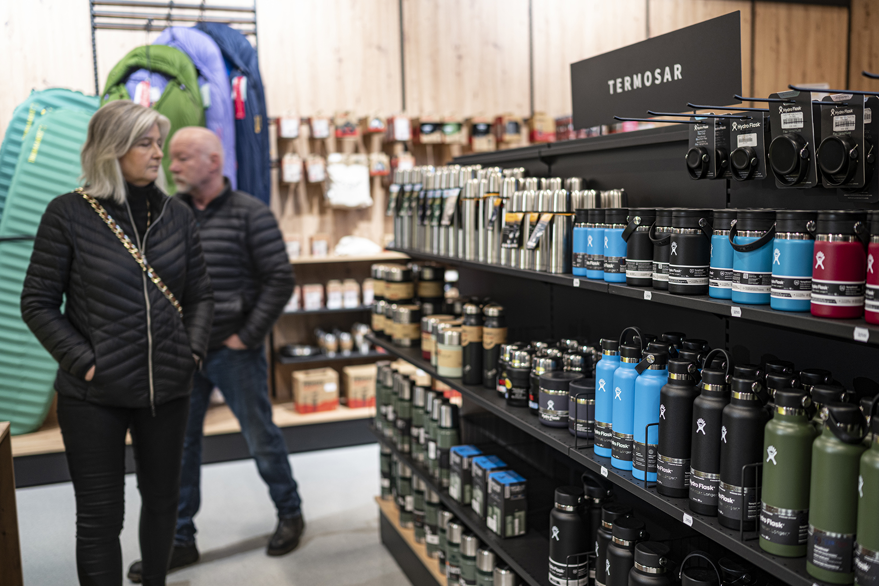 Woman looking at products in a rack of water bottles.