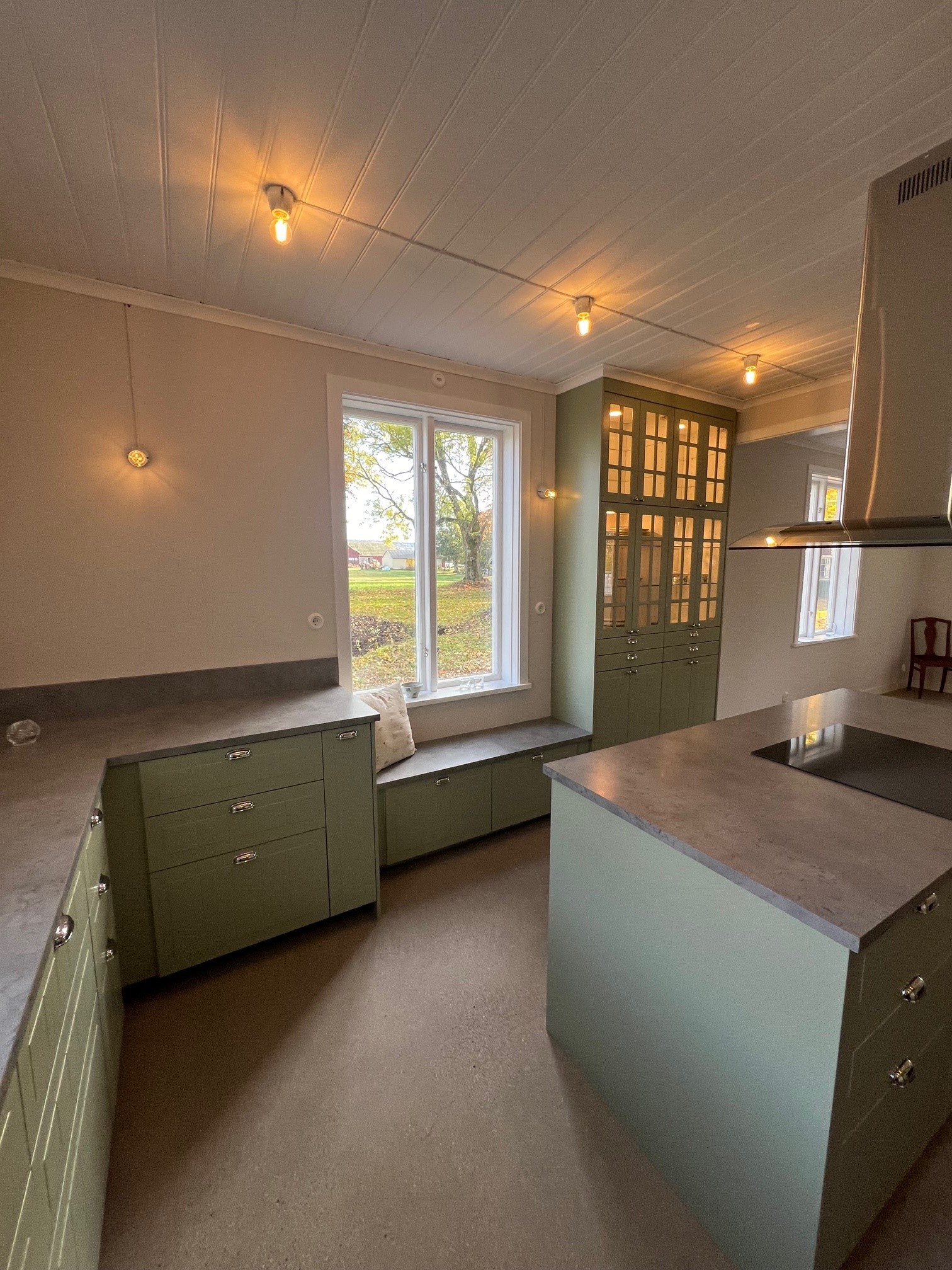 Ett stort kök med gröna luckor.