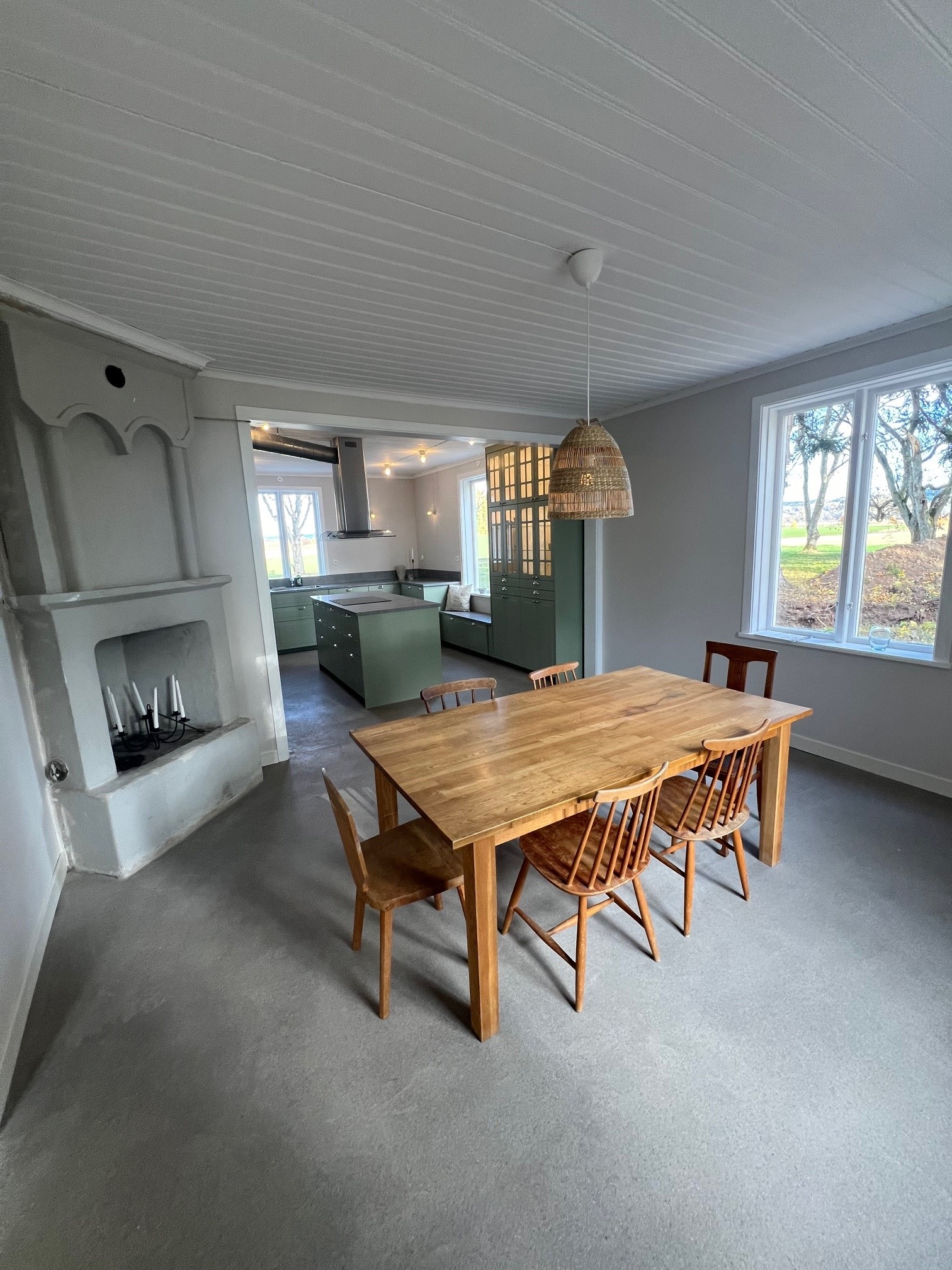 En stor ljus matplats med bord, stolar och en öppen spis