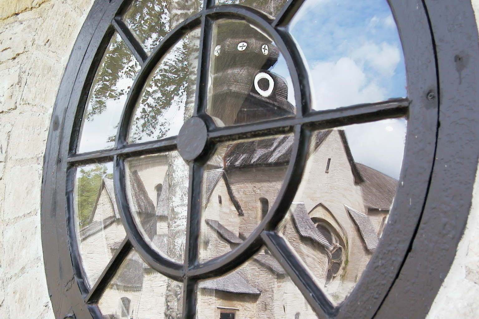 Church window with a reflection of the old monastery church in Varnhem.
