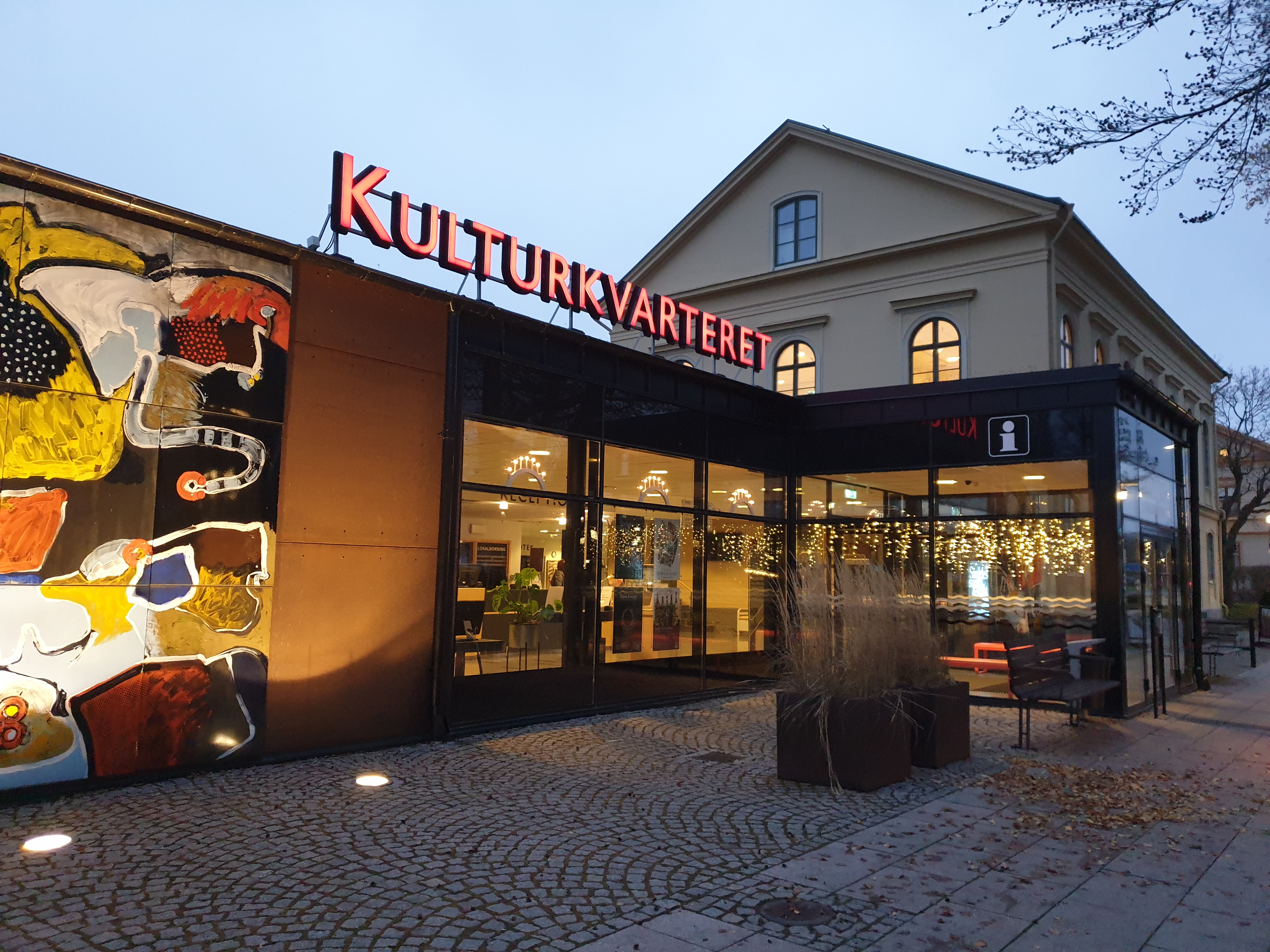 En upplyst glasentre med texten Kulturkvarteret i lysande bokstäver på taket.