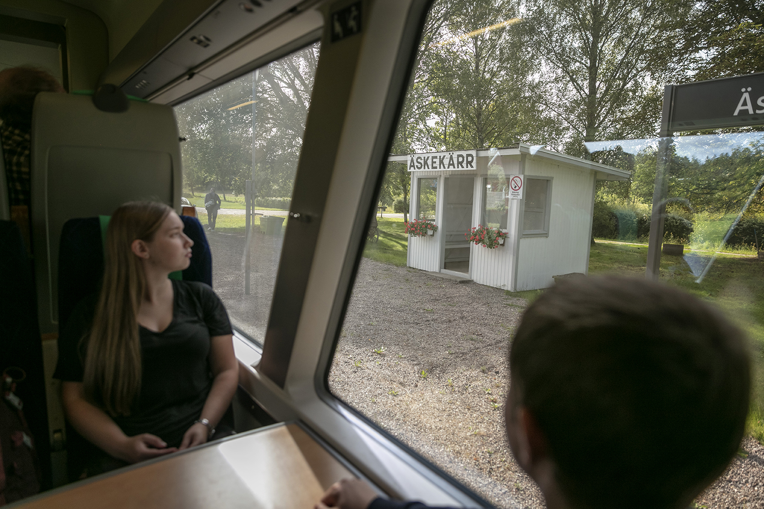 En tjej tittar ut genom ett tågfönster.