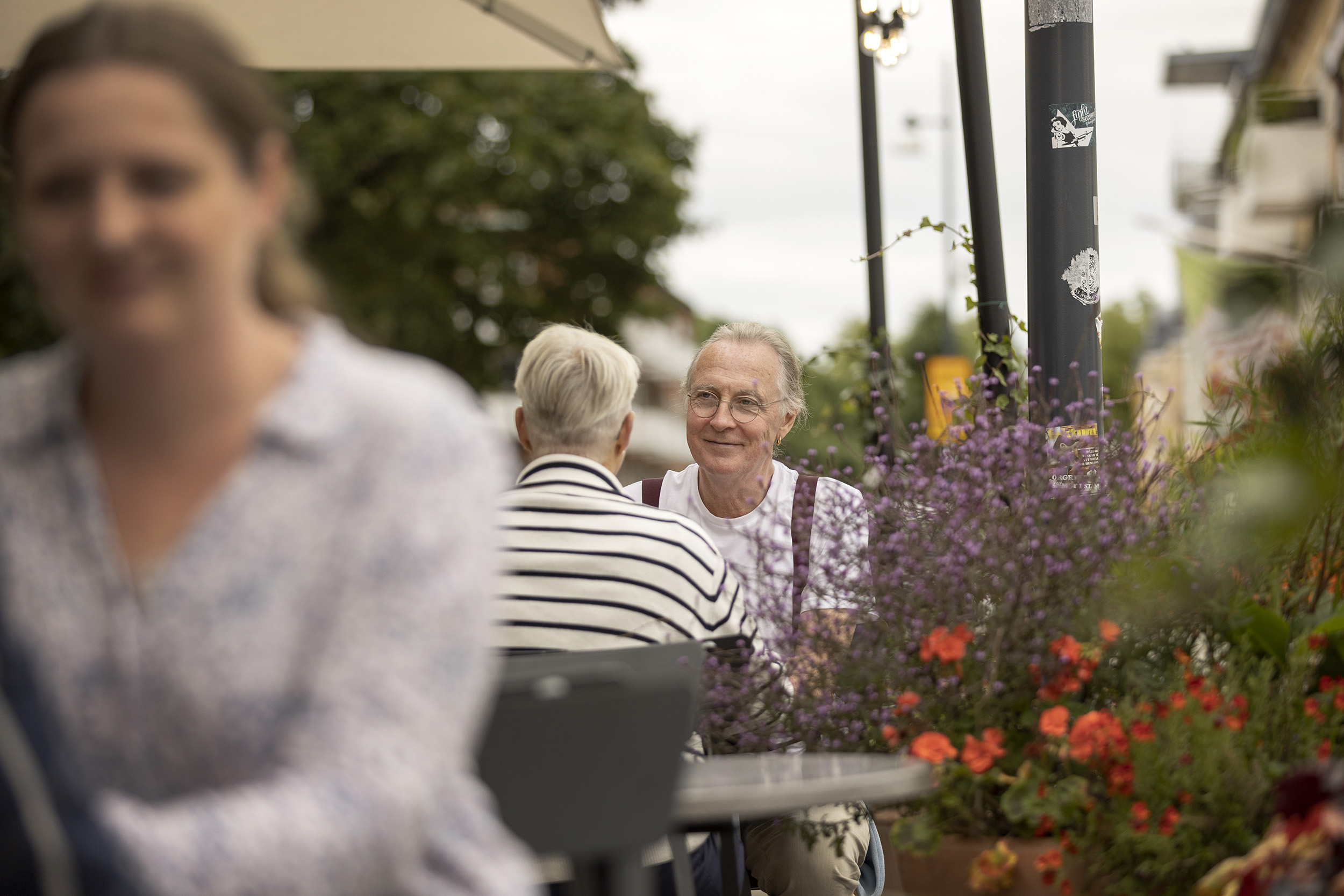 Några personer sitter vid bord på en uteservering.