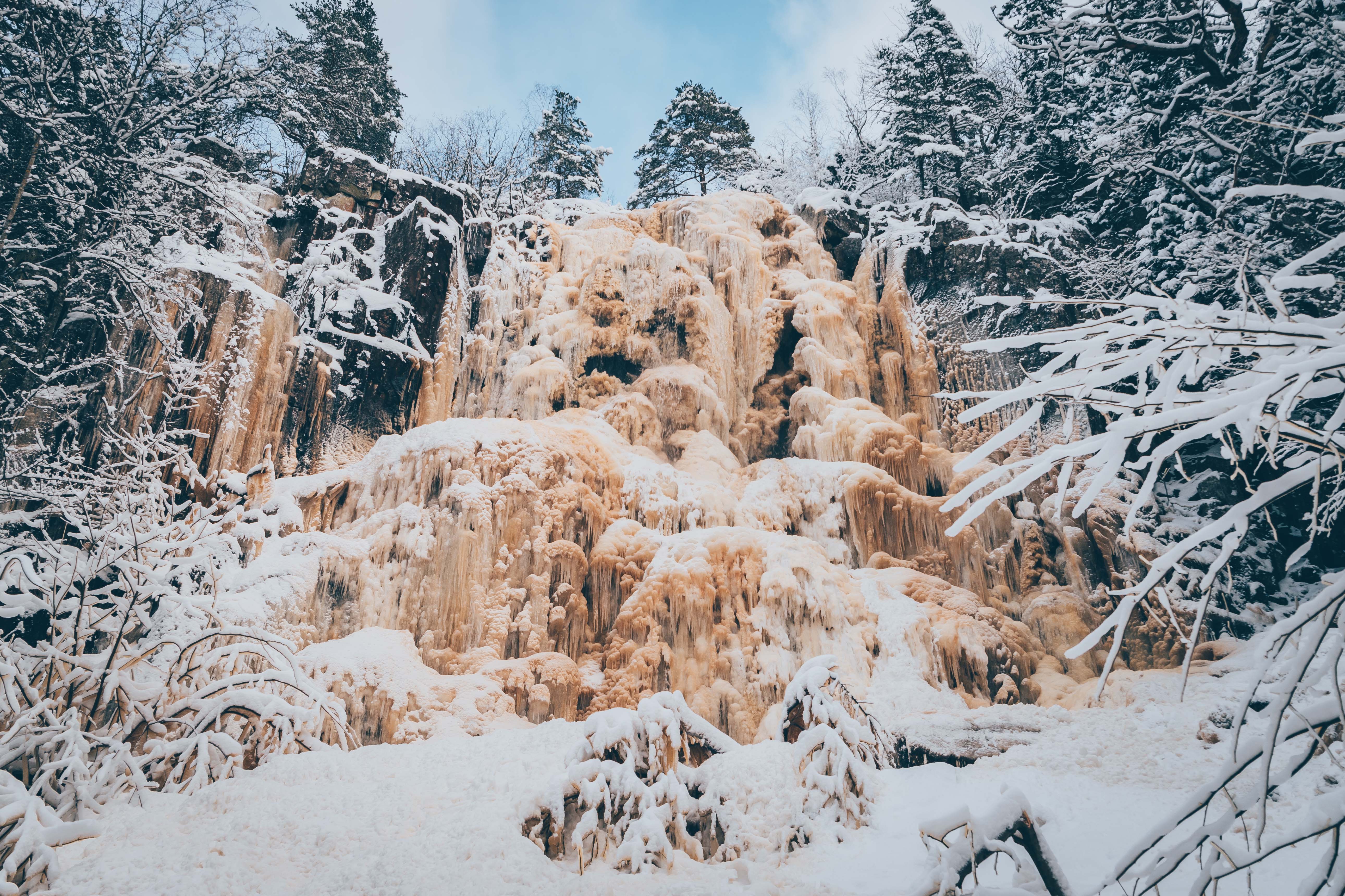 Ett fruset vattenfall med granar utmed kanterna 