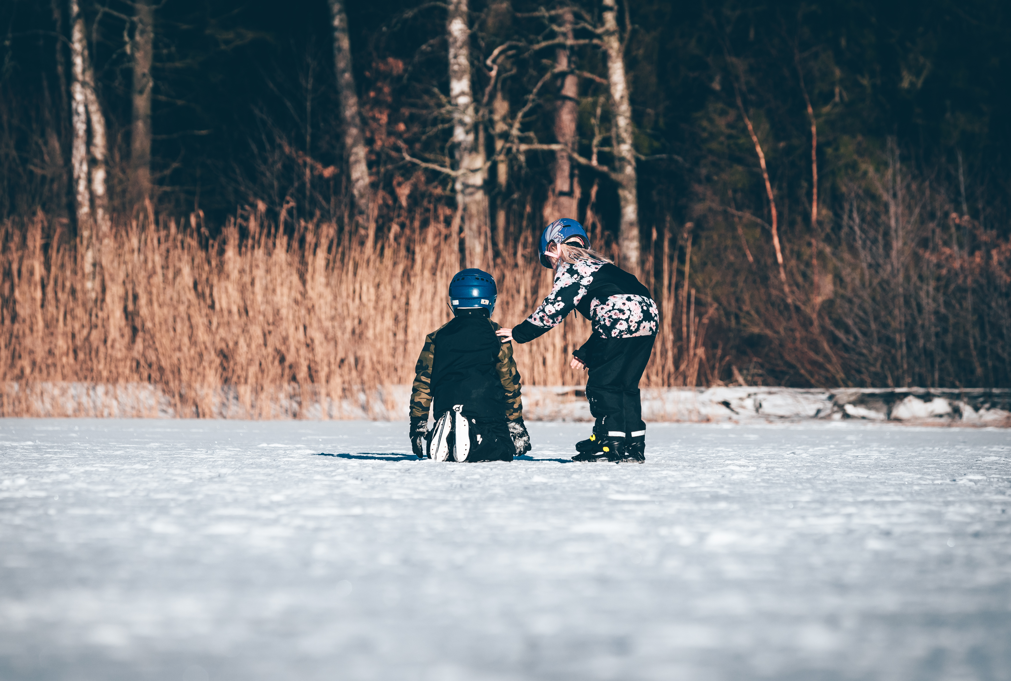 Två barn åker skridskor på en sjö