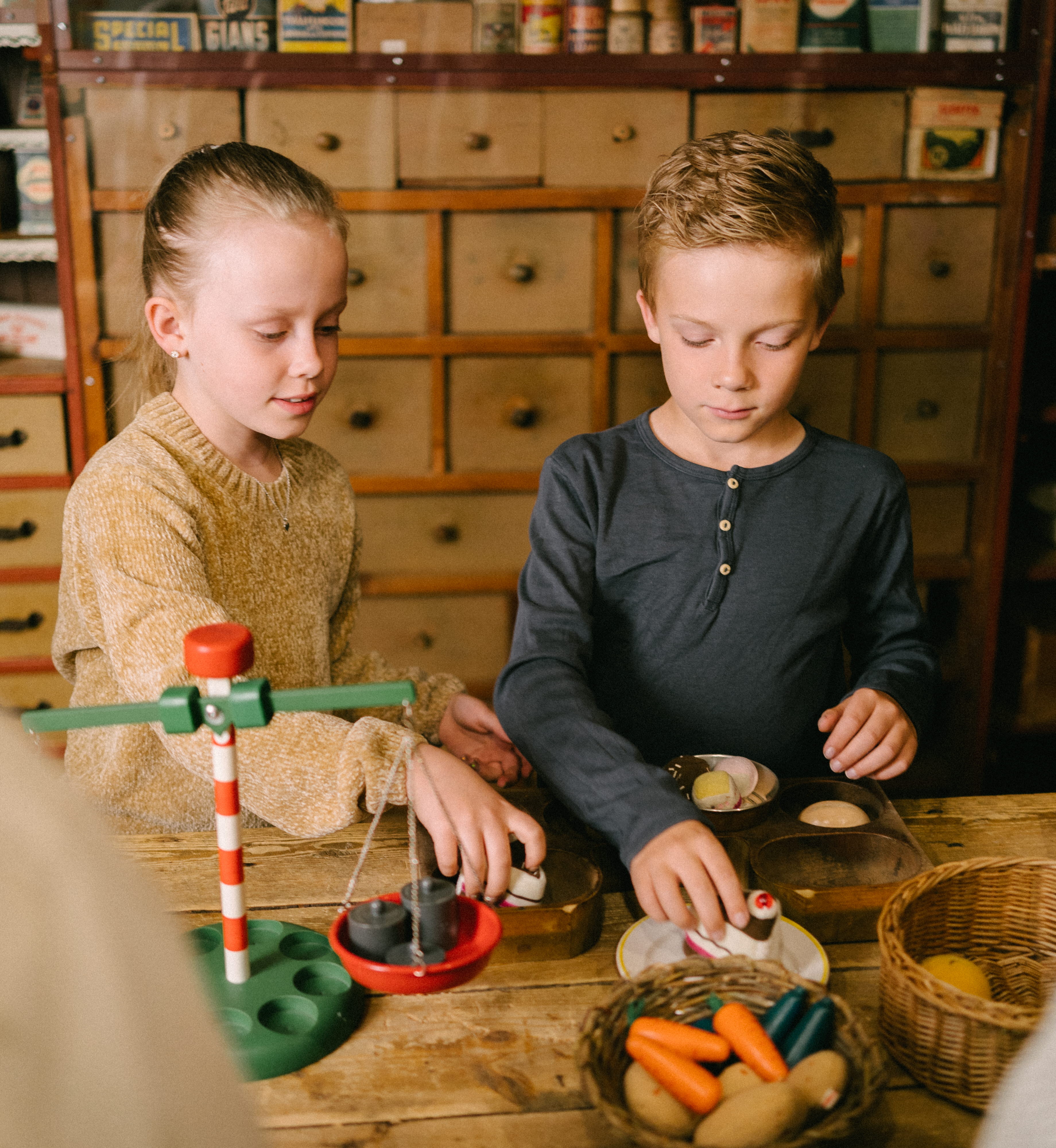 Två barn som leker i en gammaldags affär.