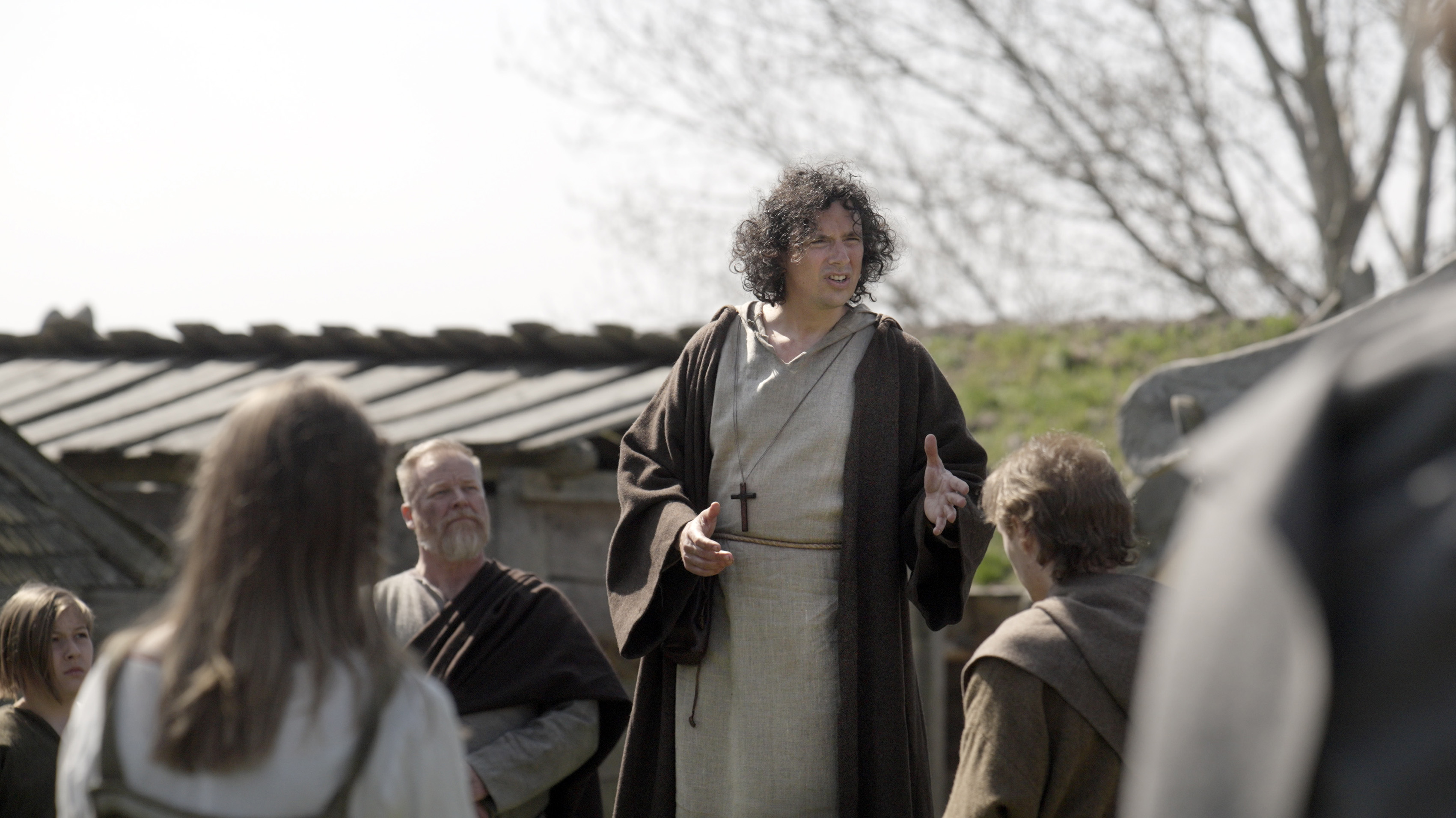 En man missionerar för några människor utomhus