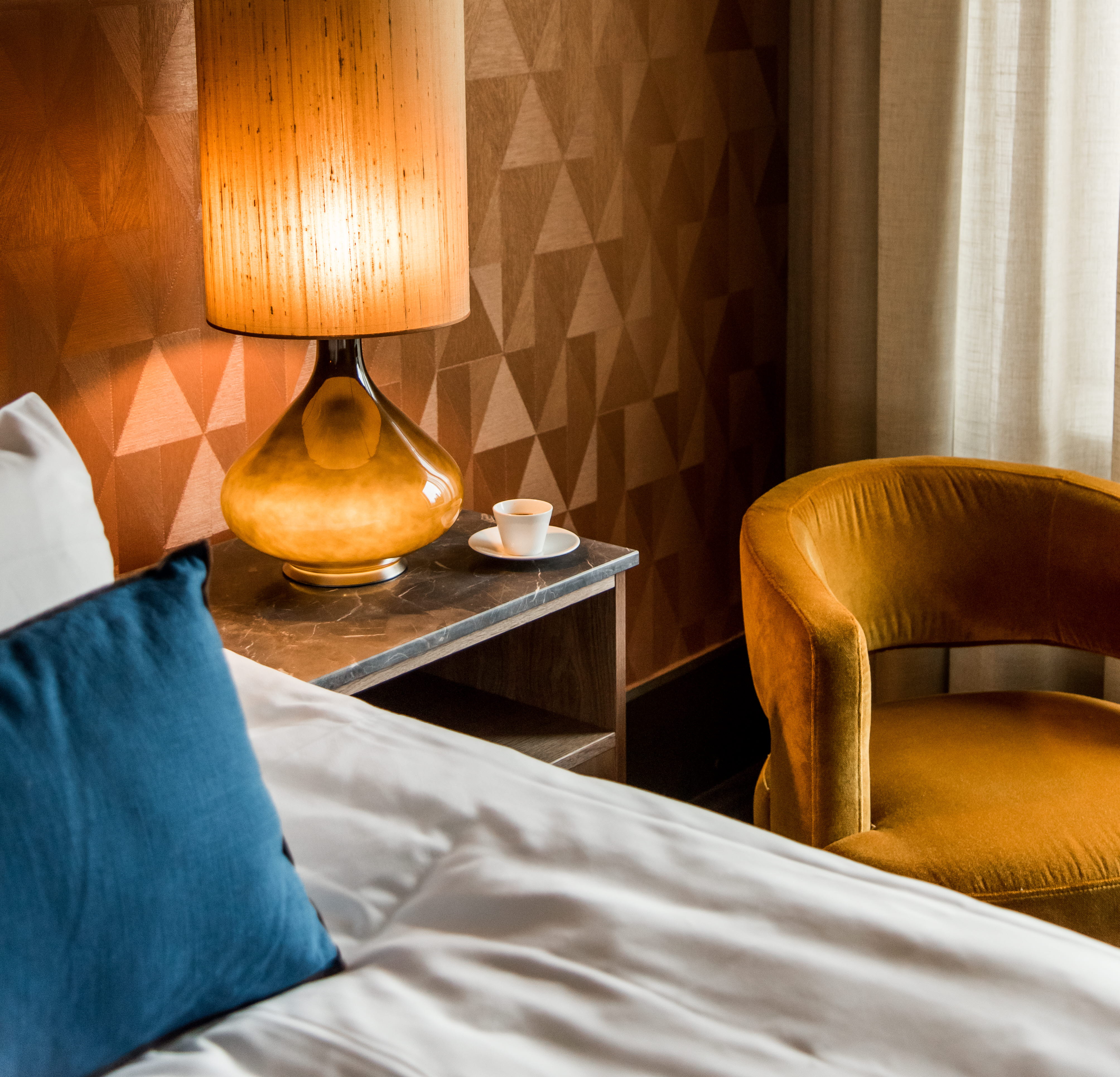 Ett hotellrum med ett sängbord med en stor lampa