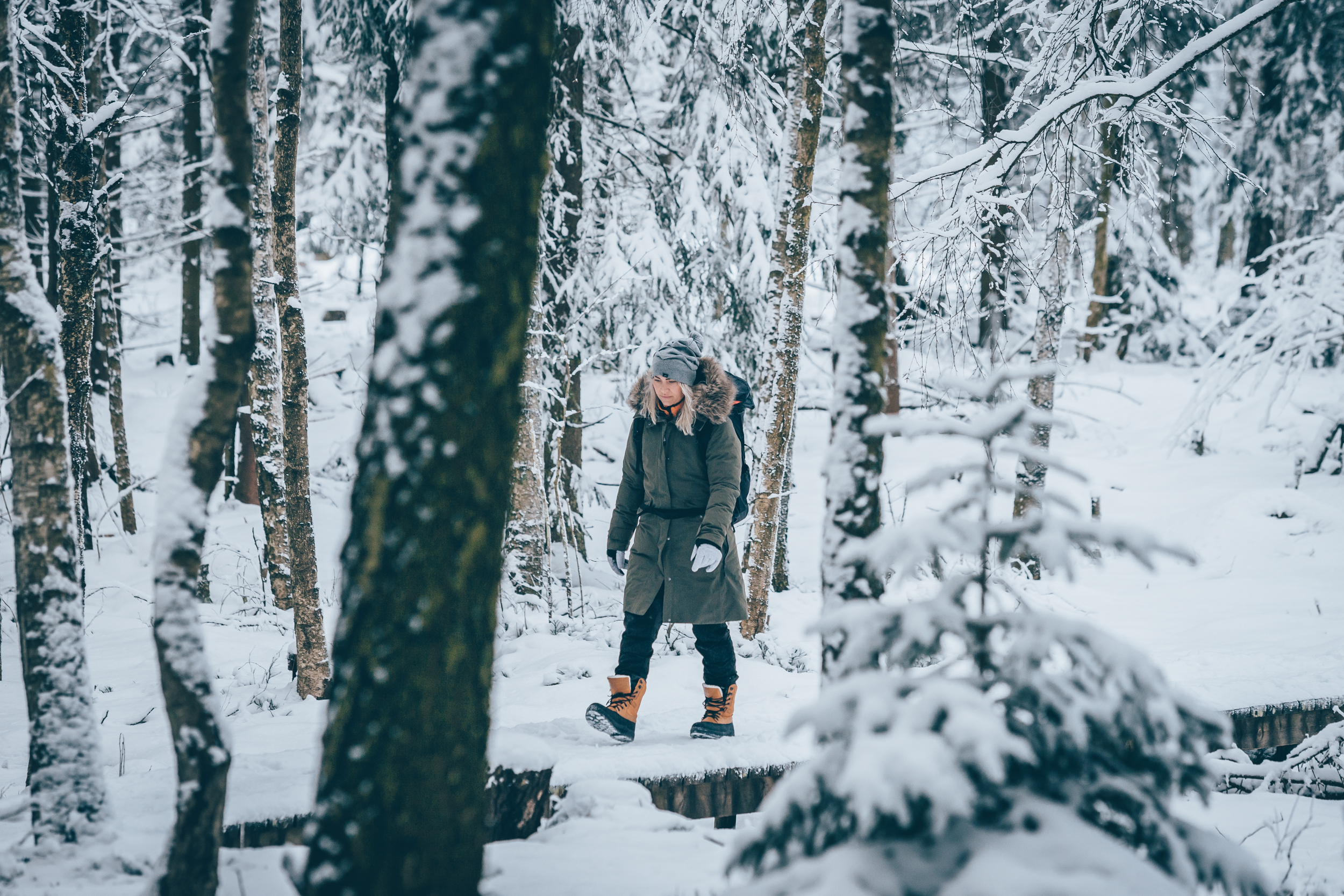 A woman walking in a snowy forest
