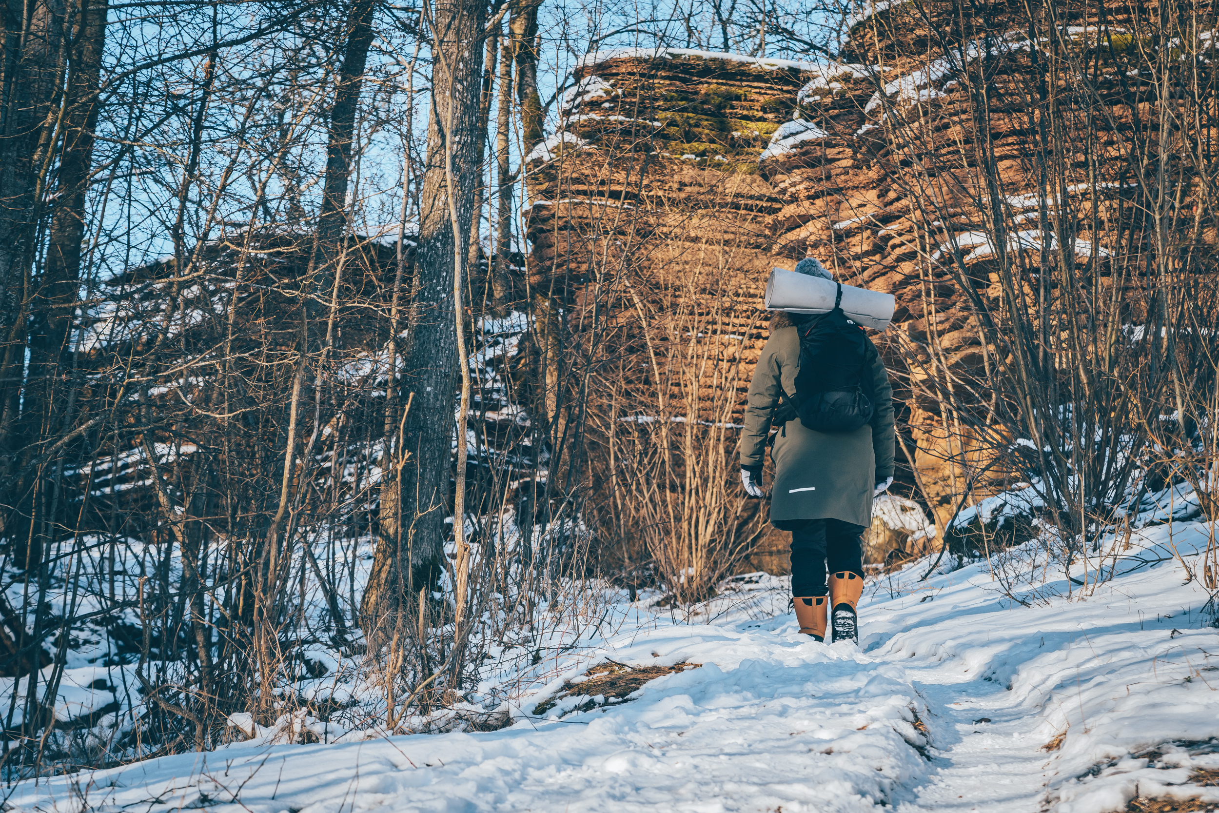 En kvinna som går omkring bland stenformationer i ett vintrigt landskap