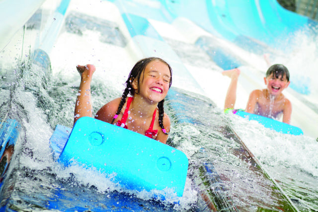 En flicka åker en vattenrutschkana på Skara Sommarland.