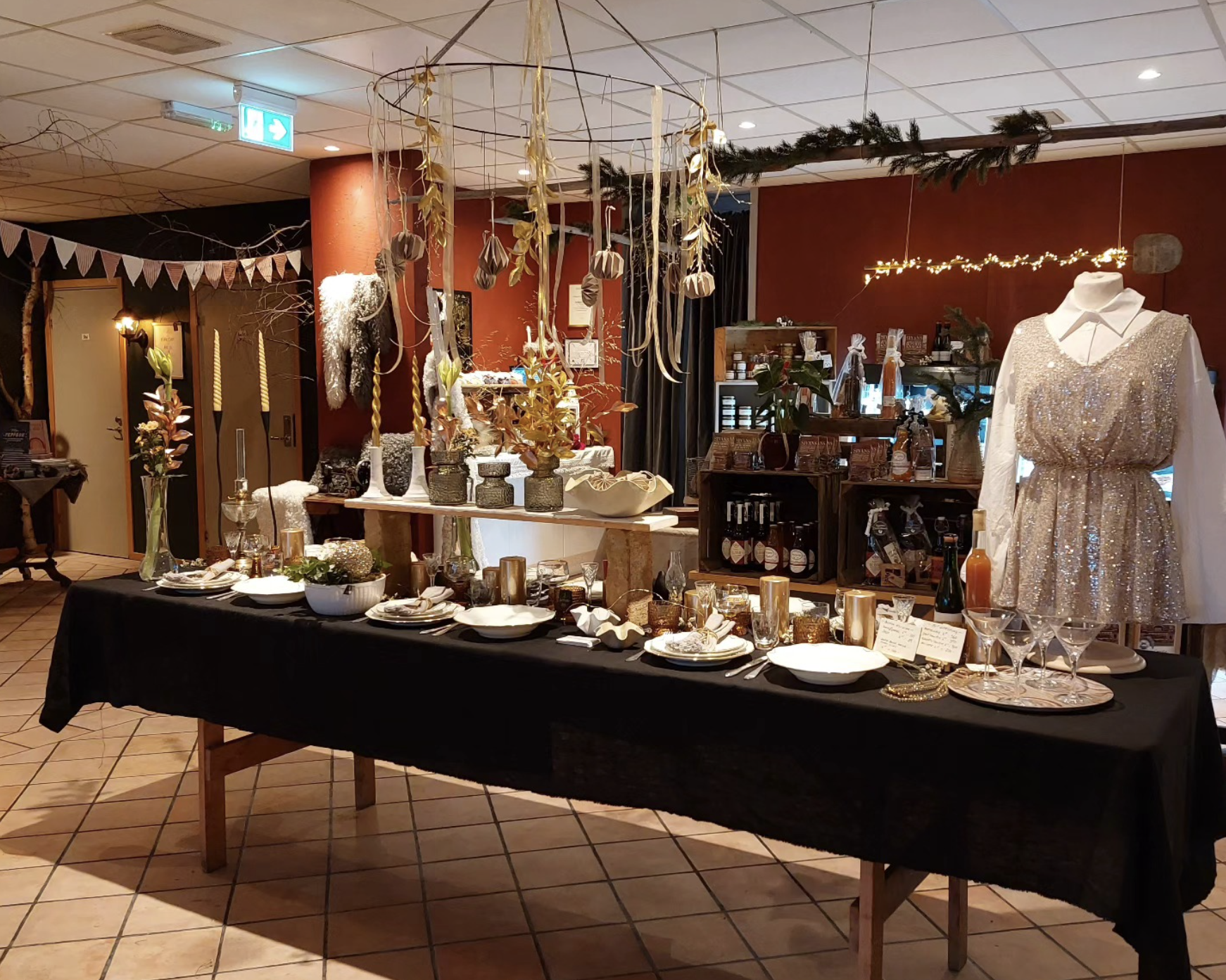 Ett stort bord med mycklet prylar på, det hänger en mobil i taket.