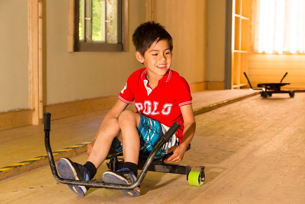 Ett barn kör trampbil.