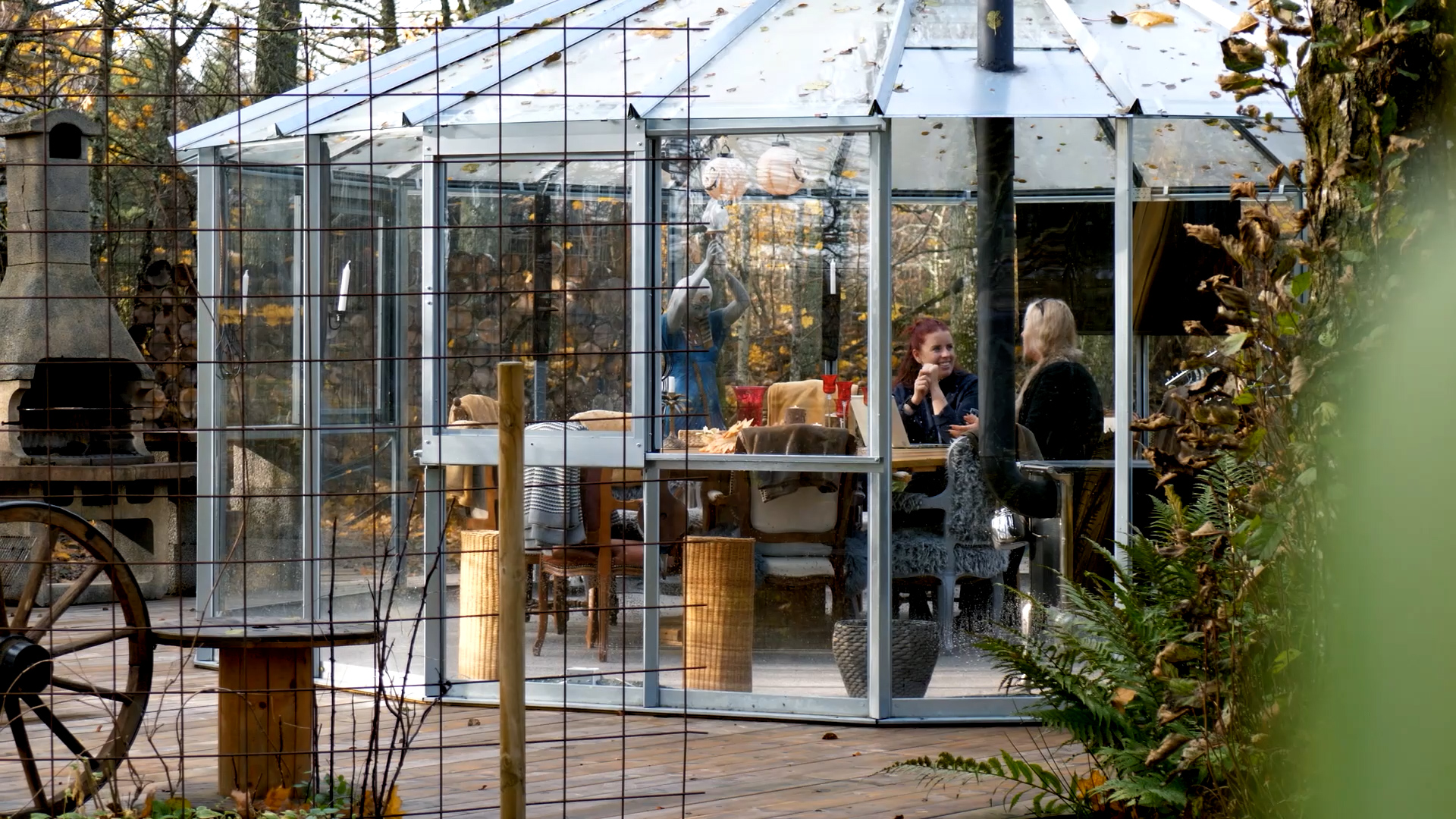Ett glashus där två personer sitt och pratar