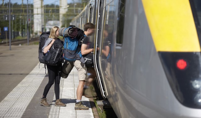 Ett par som kliver på ett gult tåg