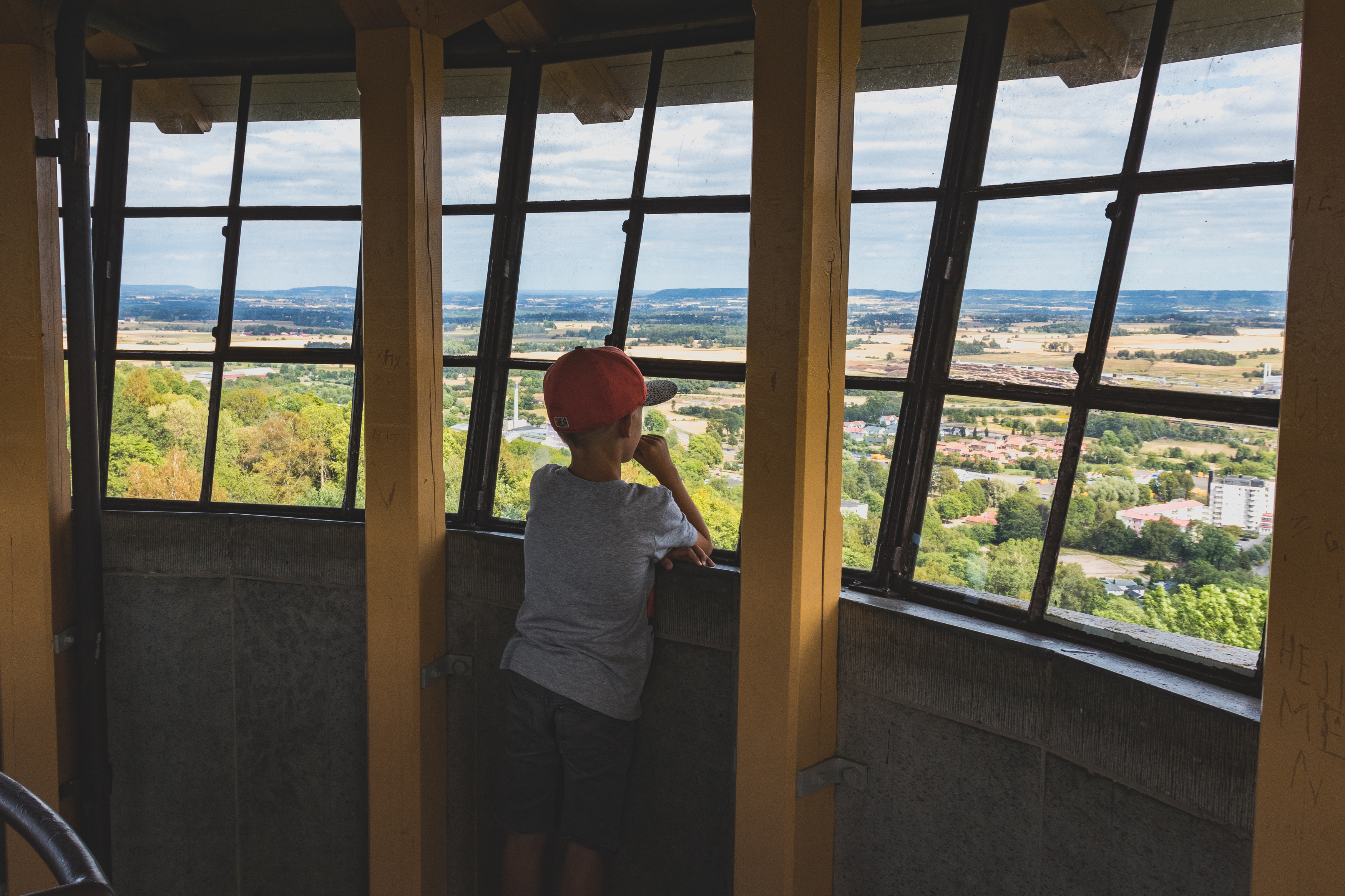 En pojke står uppe i ett torn och tittar på utsikten