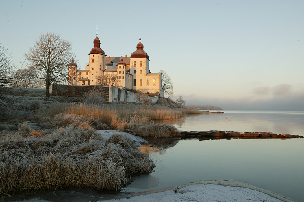 Ett vitt slott vid en sjö i ett vinterlandskap