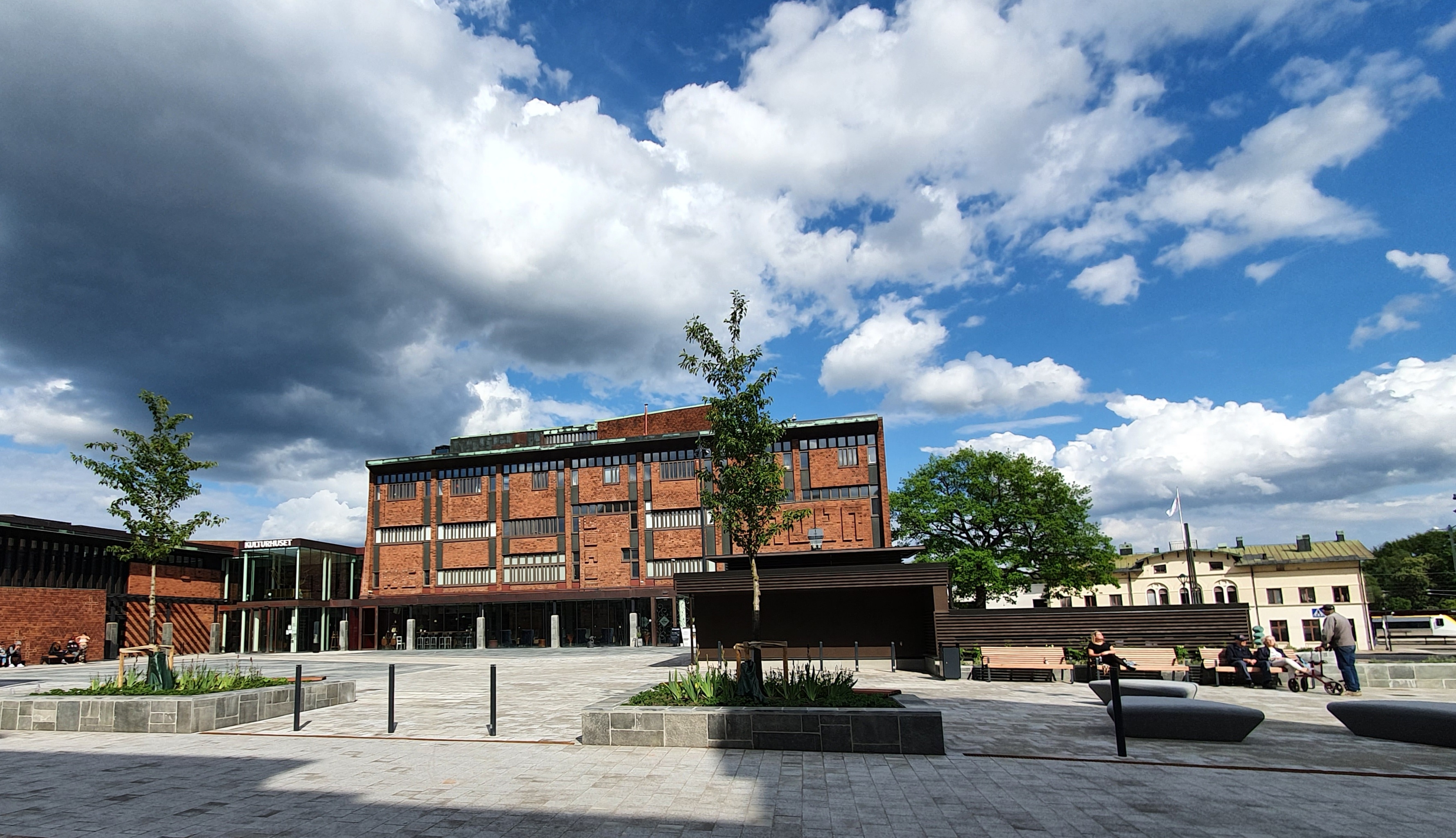 Stor röd tegelbyggnad framför ett torg