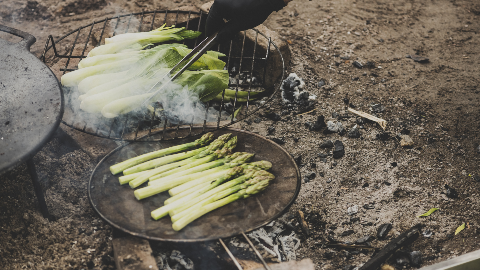 Sparris och pak choi grillas över öppen eld