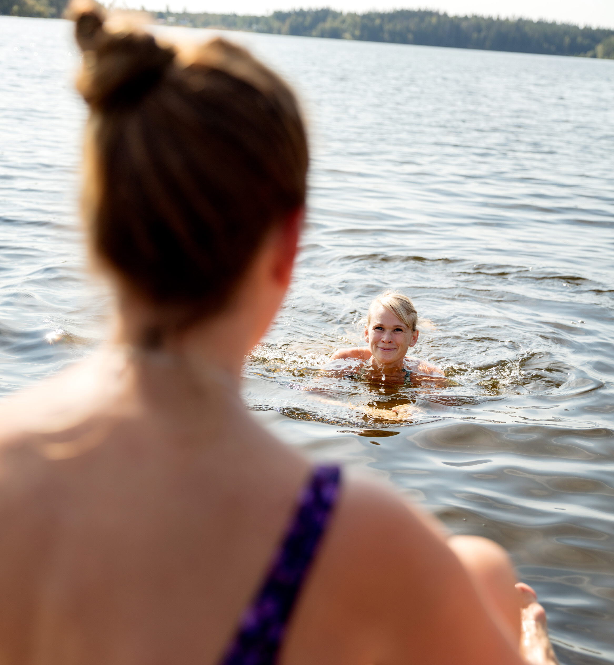 En kvinna badar i en sjö.