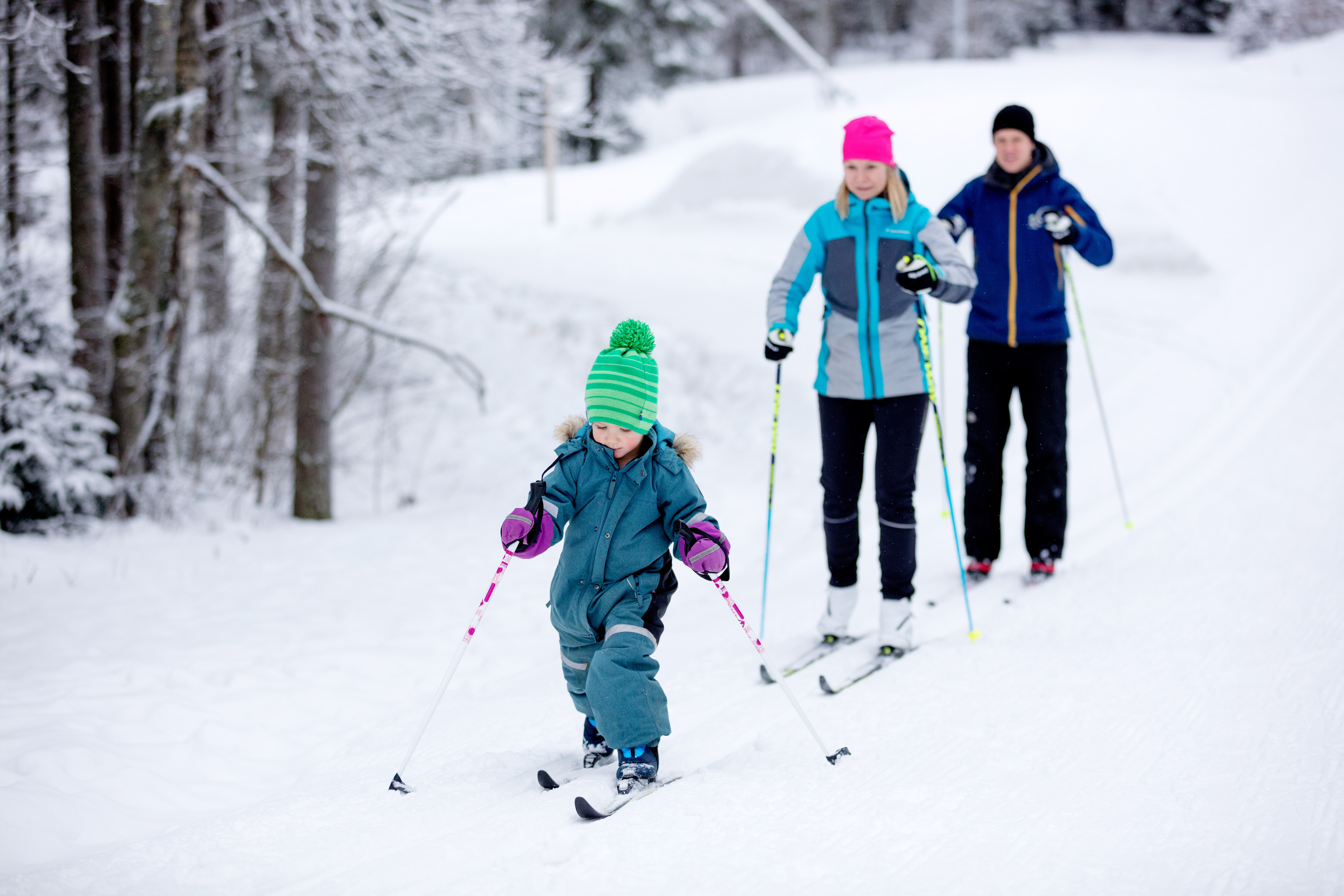 Familj med barn som åker längdskidor i skidspåret på Billingen. 