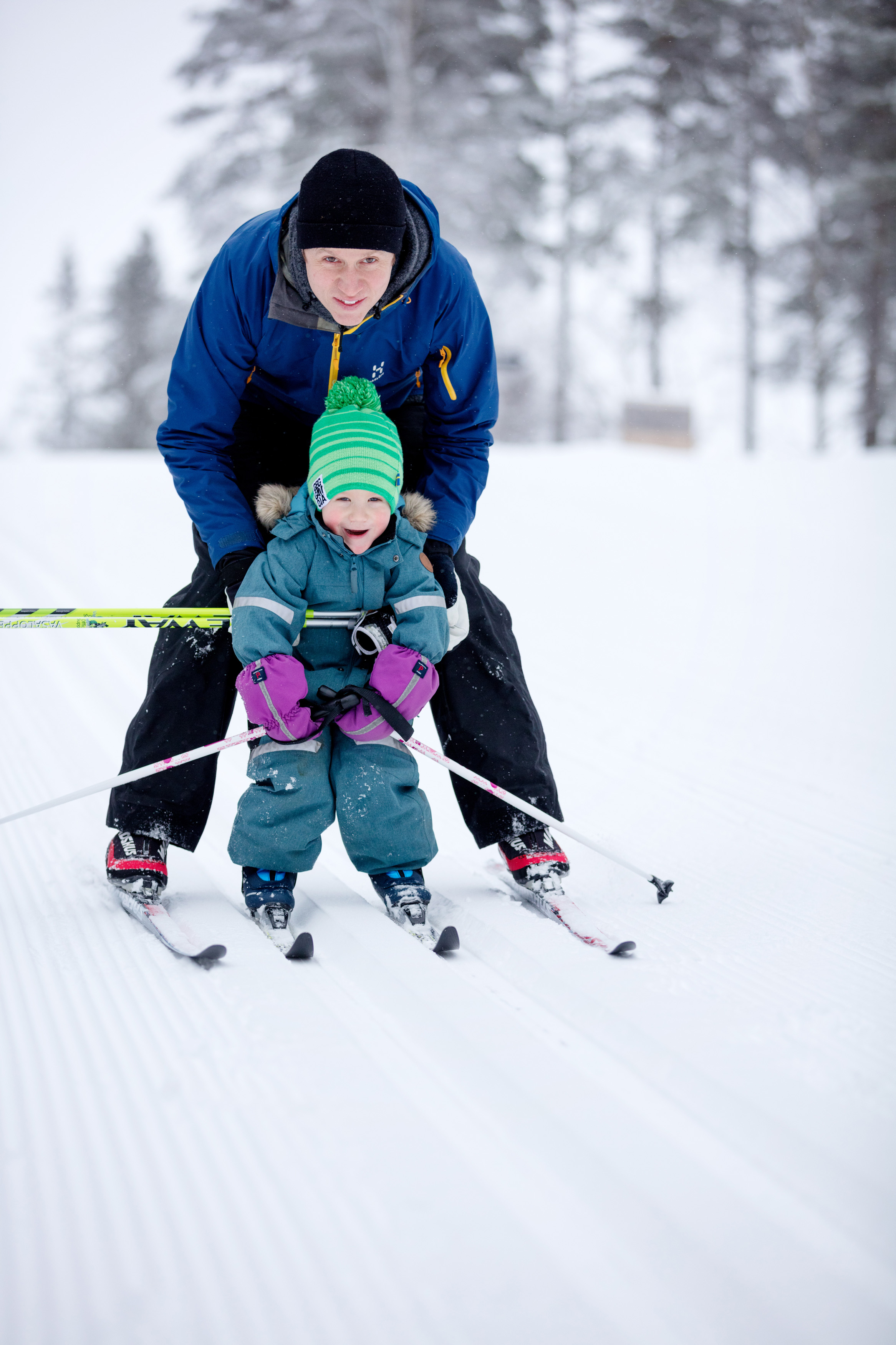 Familj med barn som åker längdskidor i skidspåret på Billingen. 